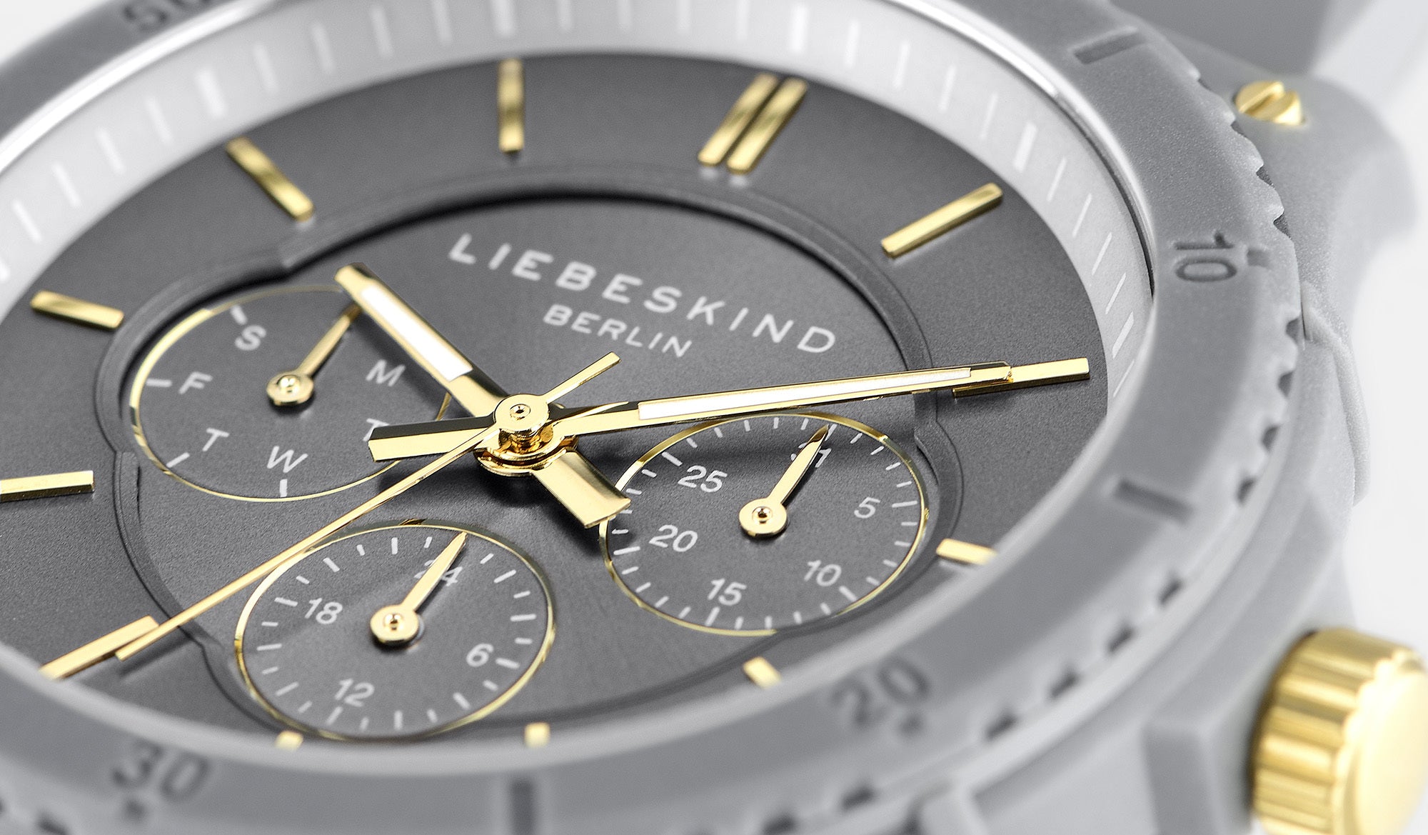 Nahaufnahme einer grau-goldenen Liebeskind Berlin Armbanduhr - Multifunktions-Statement-Uhr mit Tages-, Datums- und 24-Stunden-Ziffernblatt.