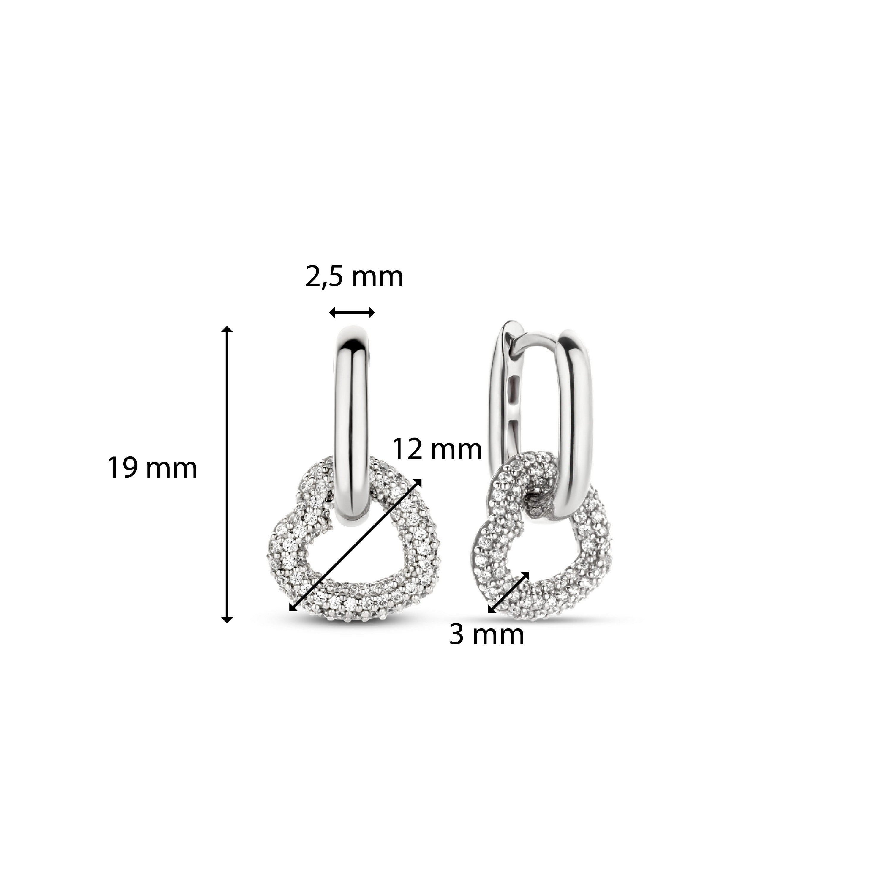 Die Ti Sento Milano Creole - The Heart Pendant Creole besteht aus silbernen Ohrringen in Herzform mit Pavé-Kristallen und den Größen 19 mm, 12 mm, 3 mm und 2,5 mm, die von der charakteristischen Eleganz von Ti Sento Milano inspiriert sind.