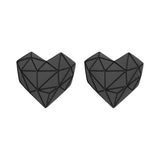 Zwei schwarze, geometrische, herzförmige Objekte mit dreieckigen Mustern erinnern an die moderne Eleganz des Liebeskind Berlin Set - Broken Heart, das sich ideal mit Ihren liebsten Roségold Ohrringen kombinieren lässt.