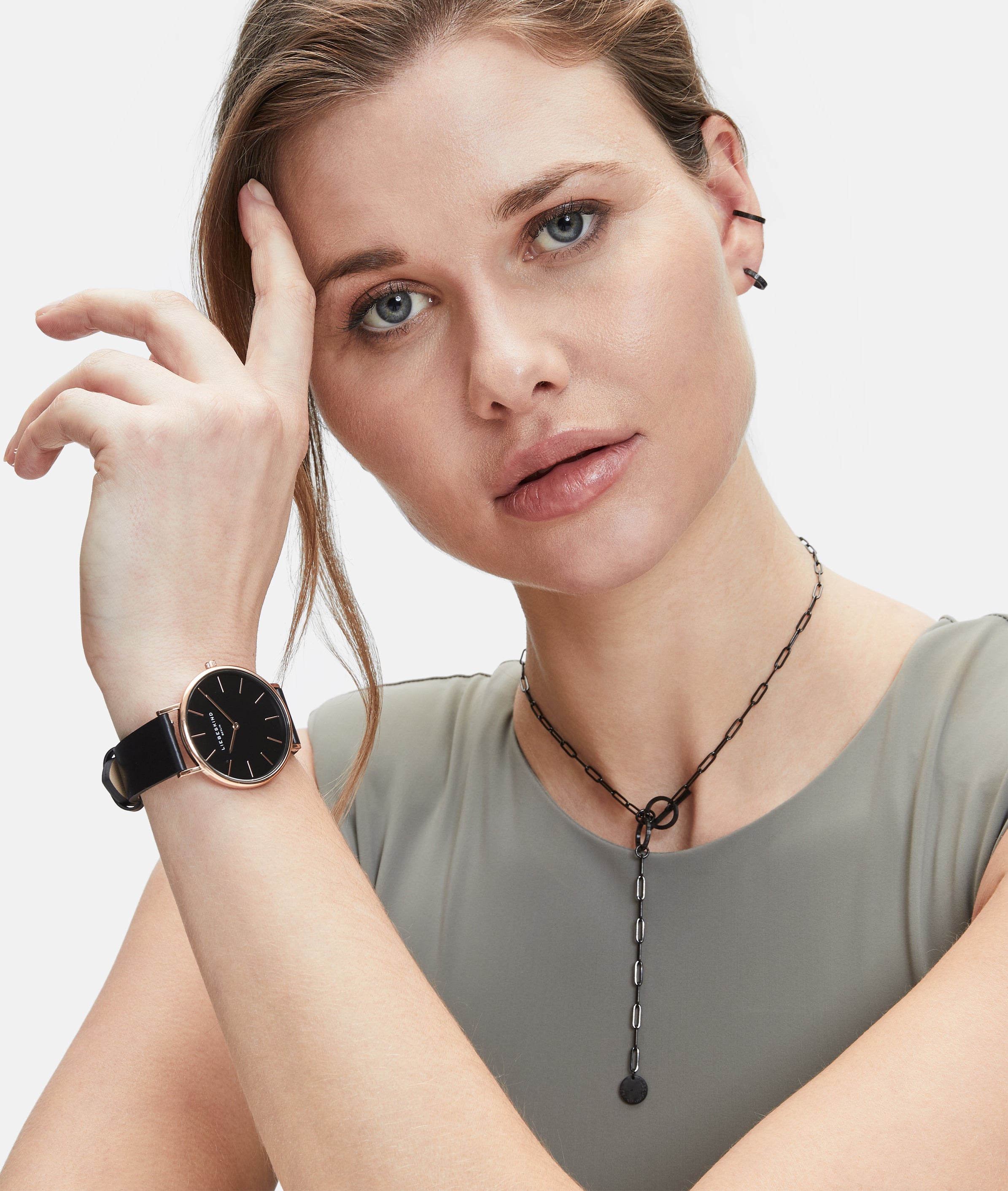 Eine Frau in einem ärmellosen Oberteil trägt die LIEBESKIND BERLIN Ear Cuff - The Small Basic Logo von Liebeskind Berlin und schaut in die Kamera.