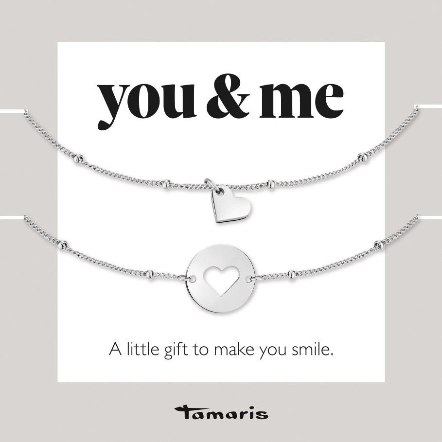 Das Tamaris Set - You & Me von Tamaris besteht aus zwei silbernen Armbändern mit Herzanhängern und dem Text "you & me" - eine charmante Geschenkidee für einen stilvollen Lagenlook, der ein Lächeln zaubert.