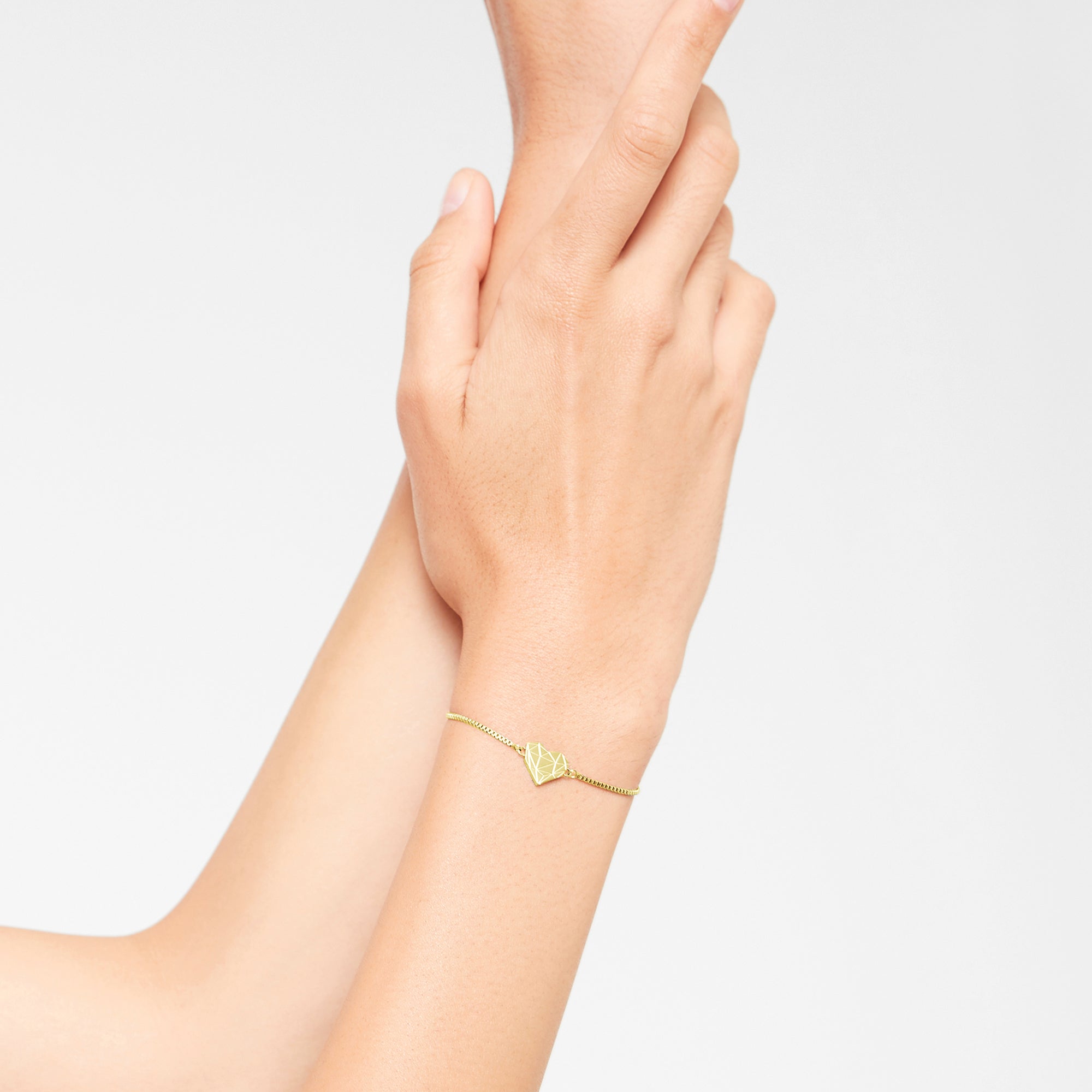 Liebeskind Berlin Armband bestehend aus einer goldenen Venezianerkette und einem geometrischen Herzanhänger mit grafischen Elementen; Tragebild