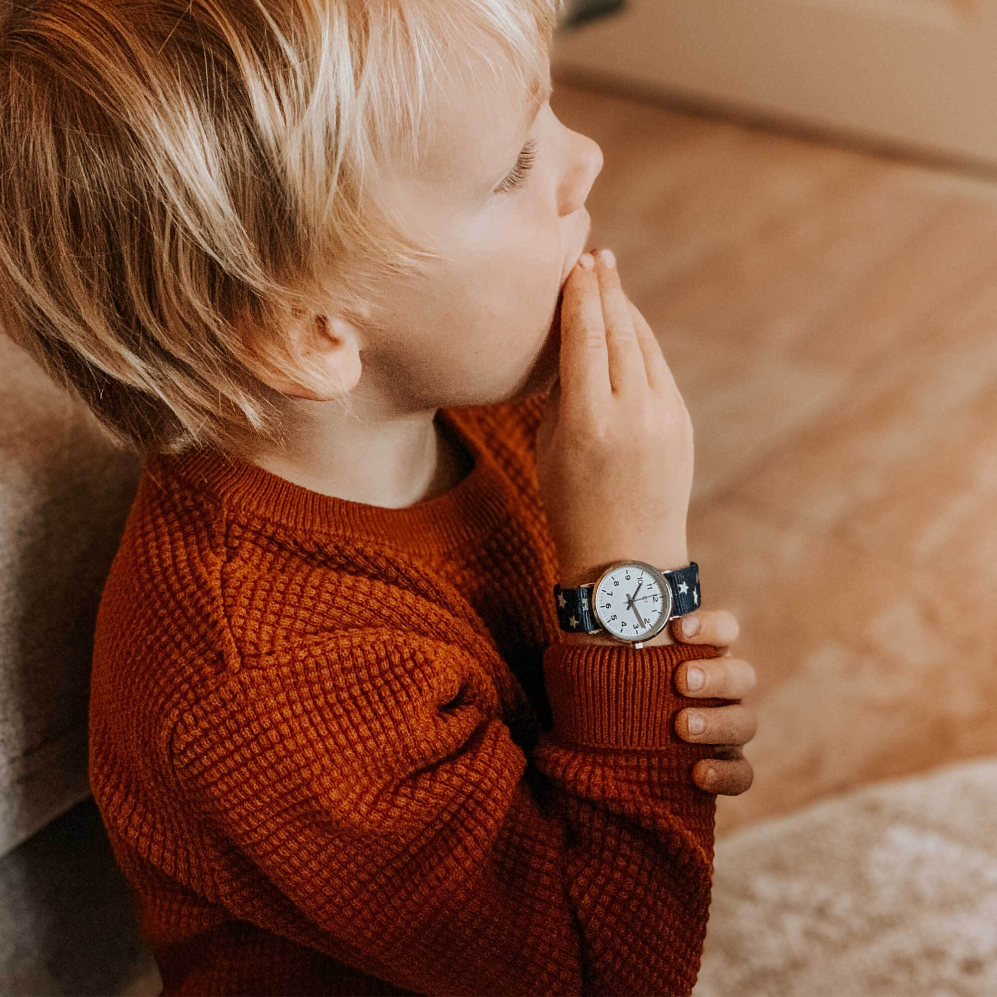 Cool Time Kids Armbanduhr mit silbernem Zifferblatt und blauem Textilband mit kleinen, weißen Sternen; Tragebild