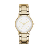 Die DKNY Armbanduhr - The Basic Must-Have Minimalist präsentiert sich mit goldfarbenem Metallgliederband, weißem Zifferblatt und minimalistischen goldenen Stundenmarkierungen auf weißem Hintergrund.