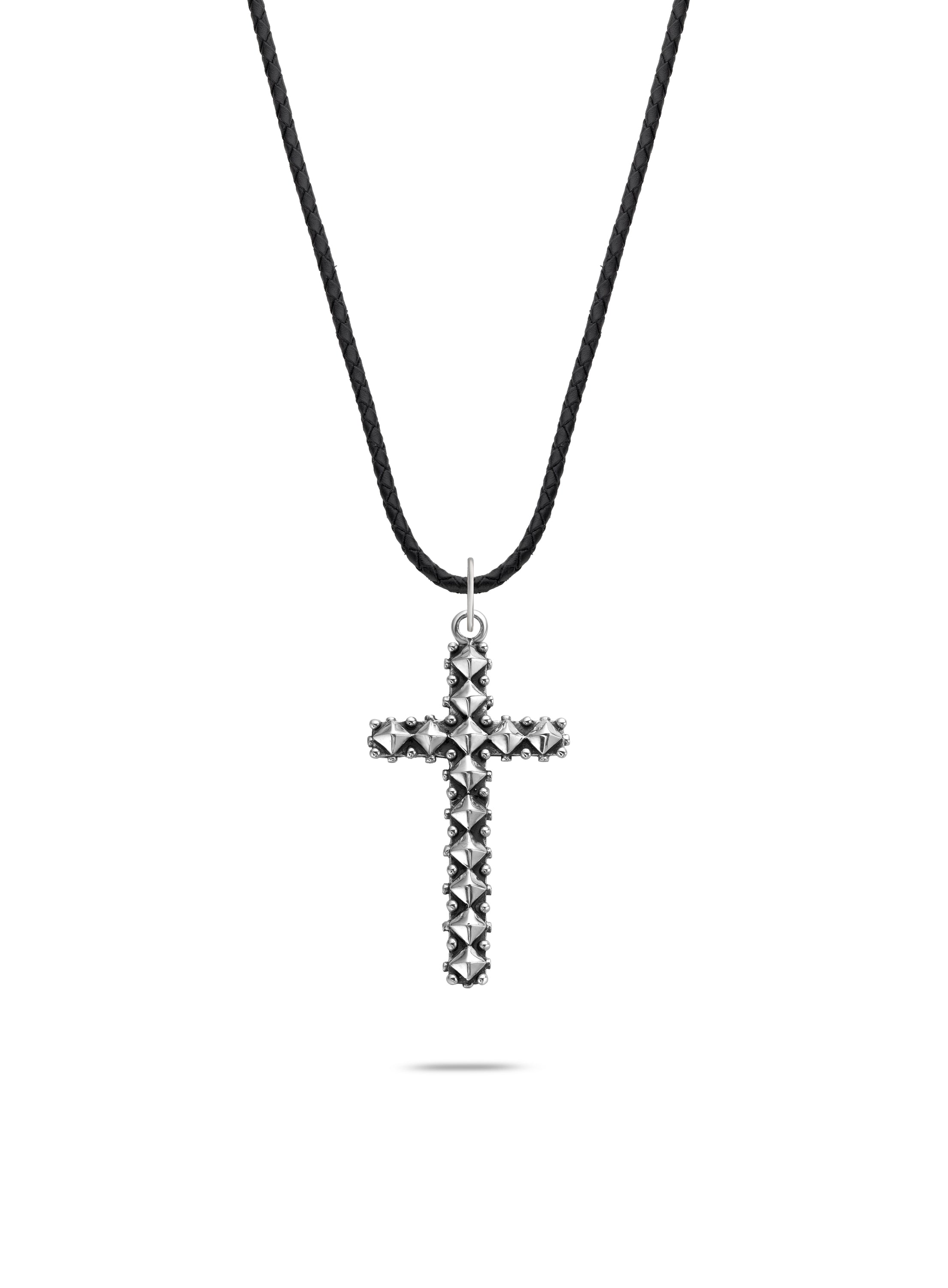 Rebel & Rose Halskette - Das Nietenkreuz: Diese auffällige silberne Halskette von Rebel & Rose hat strukturierte Details und hängt elegant an einer schwarzen Kordel, die auf einem weißen Hintergrund präsentiert wird.