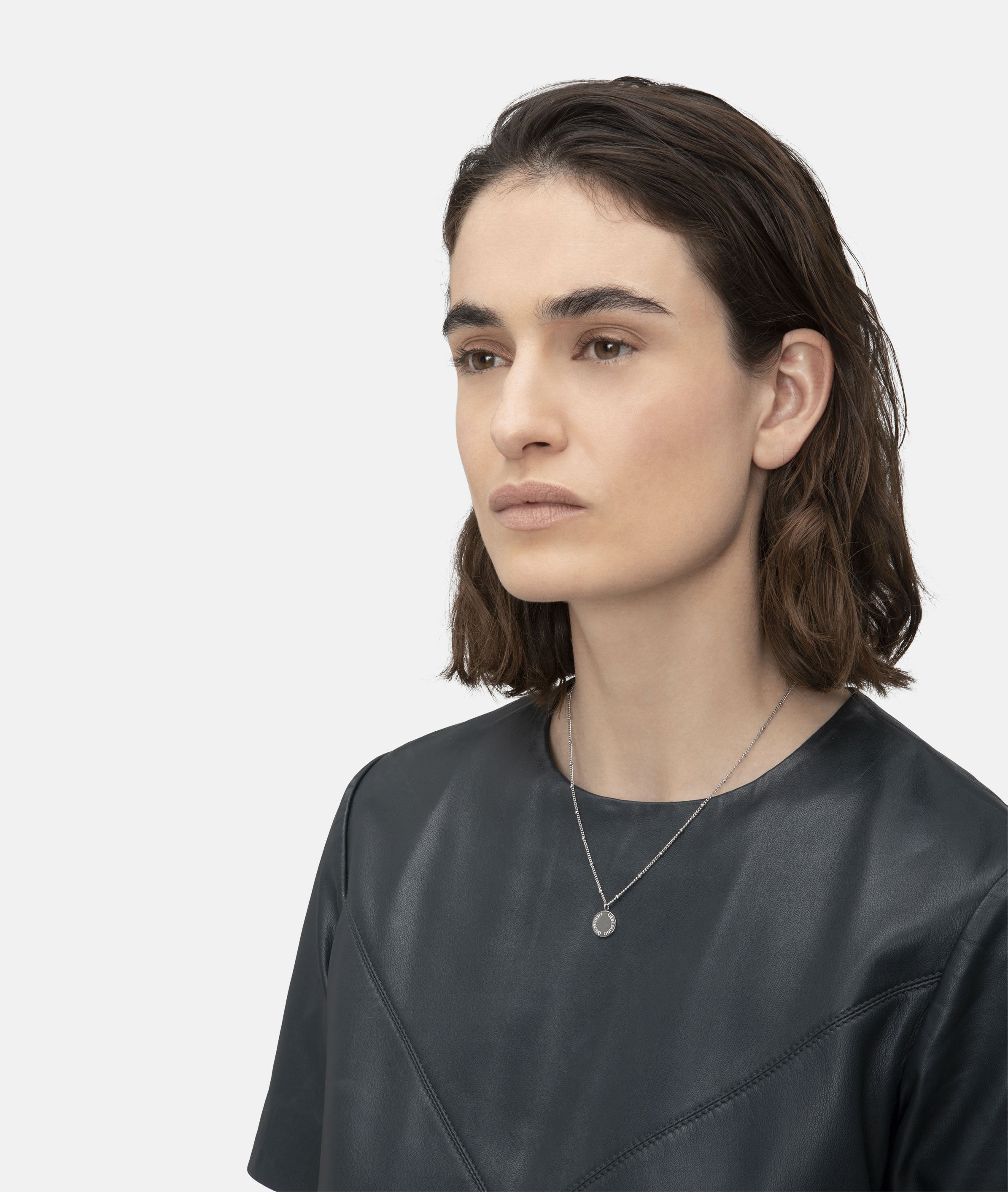 Liebeskind Berlin Halskette bestehend aus einer silbernen Gliederkette mit kleinen Details entlang der Kette und Plättchenanhänger mit Logogravur; Tragebild