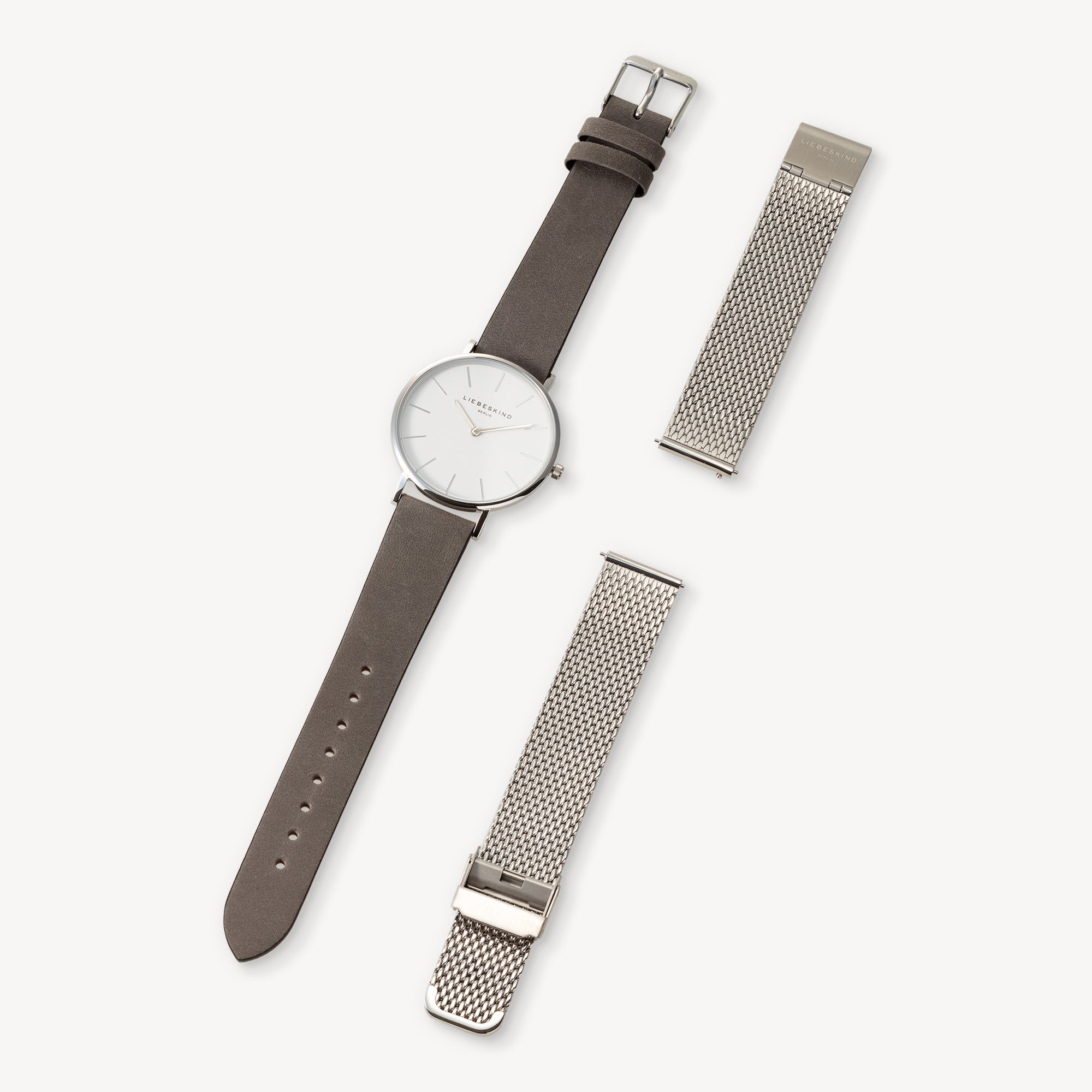 Minimalistische Armbanduhr mit braunem Lederarmband und zwei LIEBESKIND BERLIN Uhrenband - Easy Change Mesh Bändern daneben, alle von Liebeskind Berlin, passend für 18mm Armbänder für müheloses Wechseln des Stils.