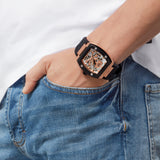 Eine Person in Jeans mit einer Hand in der Tasche, die eine stylische, großflächige Philipp Plein Armbanduhr trägt - Das $Skelett.