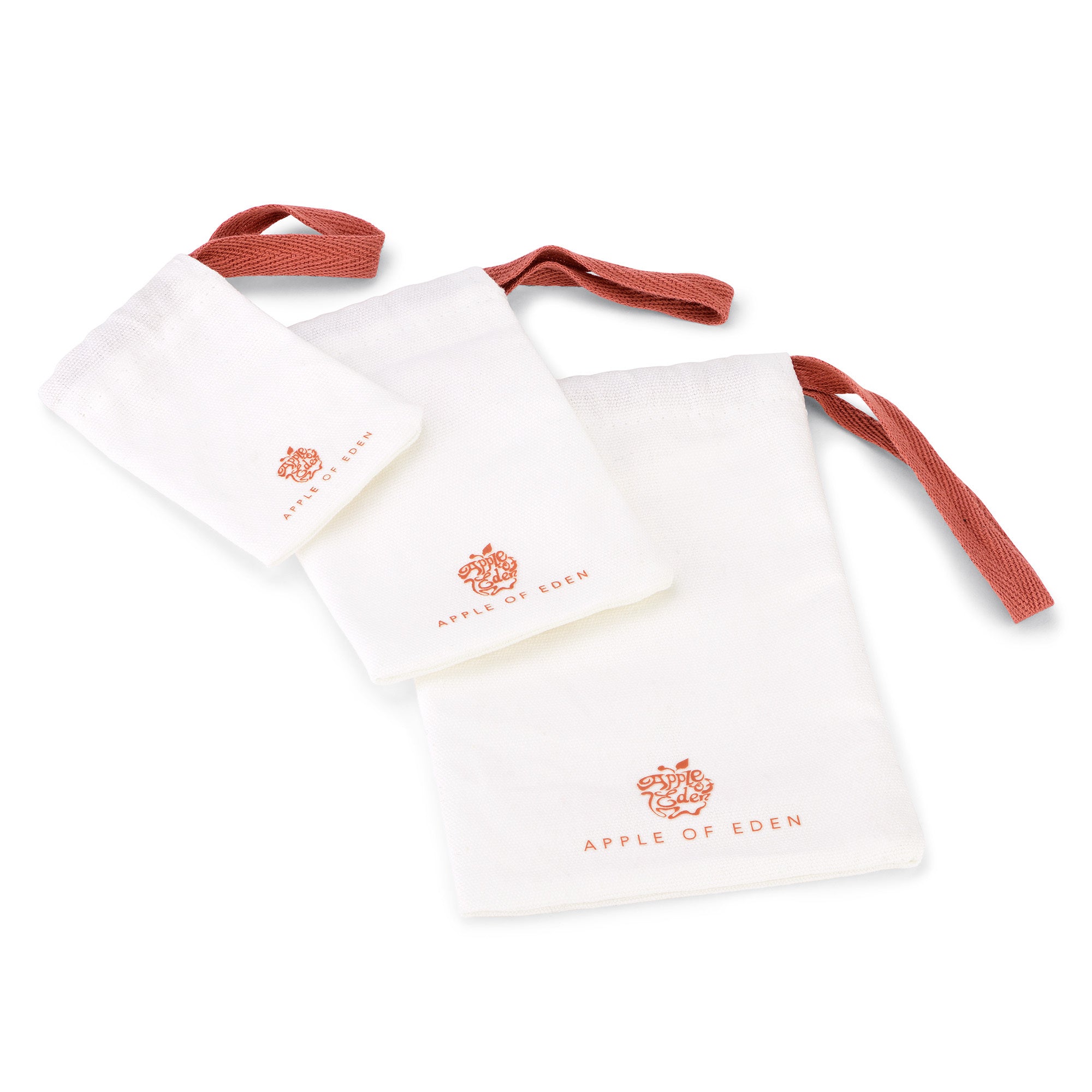 Drei weiße Kordelzugtaschen mit roten Griffen und dem Apple of Eden Logo, ideal zur Aufbewahrung Ihres Apple of Eden Armreifs - The Chic Wave - Wide oder anderen eleganten Damen Schmucks.