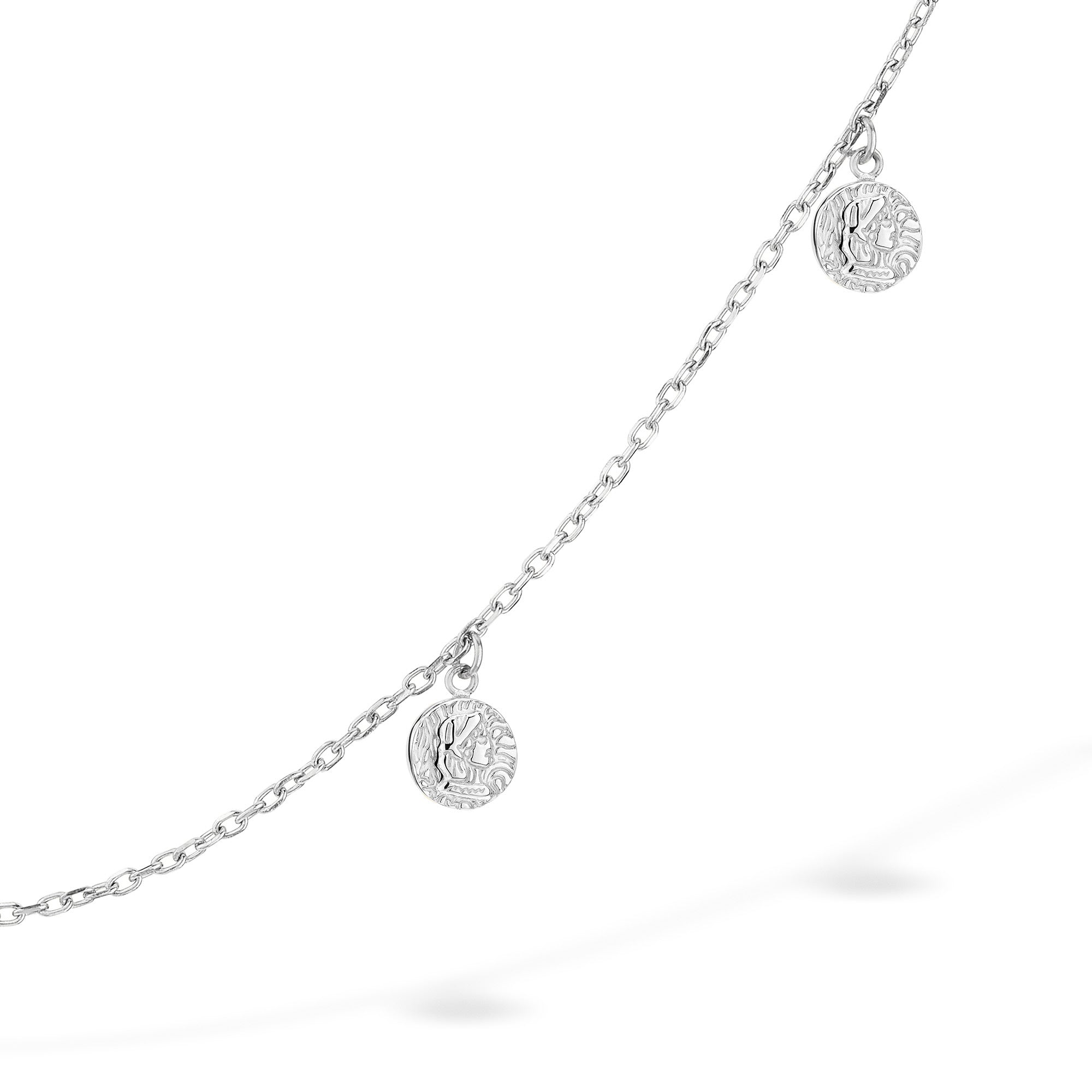 Die Tamaris Halskette - Coin ist eine filigrane silberne Ankerkette mit zwei kleinen runden Münz-Charms aus Edelstahl von Tamaris, die jedem Look auf weißem Hintergrund eine elegante Note verleiht.