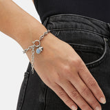 Fynch-Hatton Armband bestehend aus einer flachen, silbernen Gliederkette mit Herzcharm und lila Schmuckstein; Tragebild