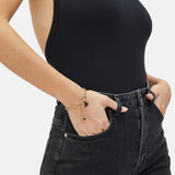 Fynch-Hatton Armband bestehend aus einer flachen, goldenen Gliederkette mit Herzcharm und schwarzem Schmuckstein; Tragebild