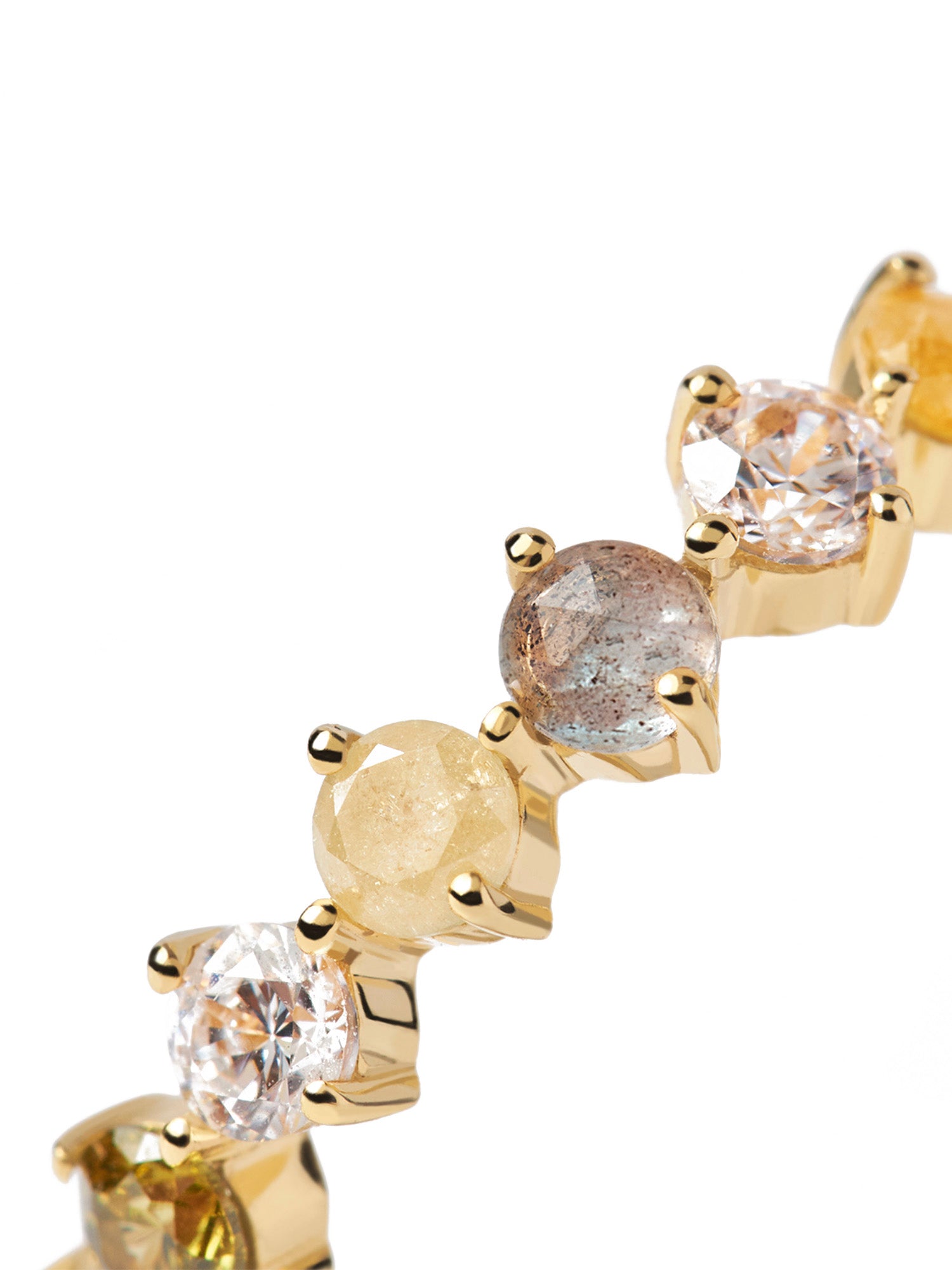 Nahaufnahme eines goldenen Armbands mit mehrfarbigen Edelsteinen in Zackenfassung, kombiniert mit dem PDPaola Motion Kara Ring in Größe 52 für einen koordinierten Look.