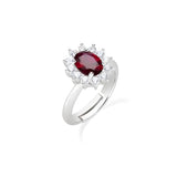 Der Amen Ring - The Red Sparkle von Amen aus 925er Sterlingsilber besticht mit einem ovalen roten Edelstein im Zentrum, umrahmt von kleinen klaren Steinen, präsentiert auf weißem Hintergrund.