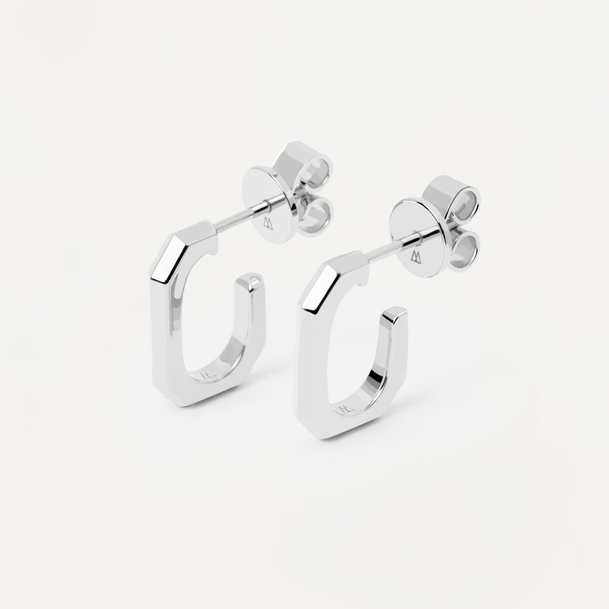 Ein Paar kleiner, geometrischer Silberohrringe - PDPaola Ohrhänger - The Chain von PDPaola - zeichnet sich durch ein modernes Design mit Ohrstecker aus, das auf einem schlichten weißen Hintergrund dargestellt ist.