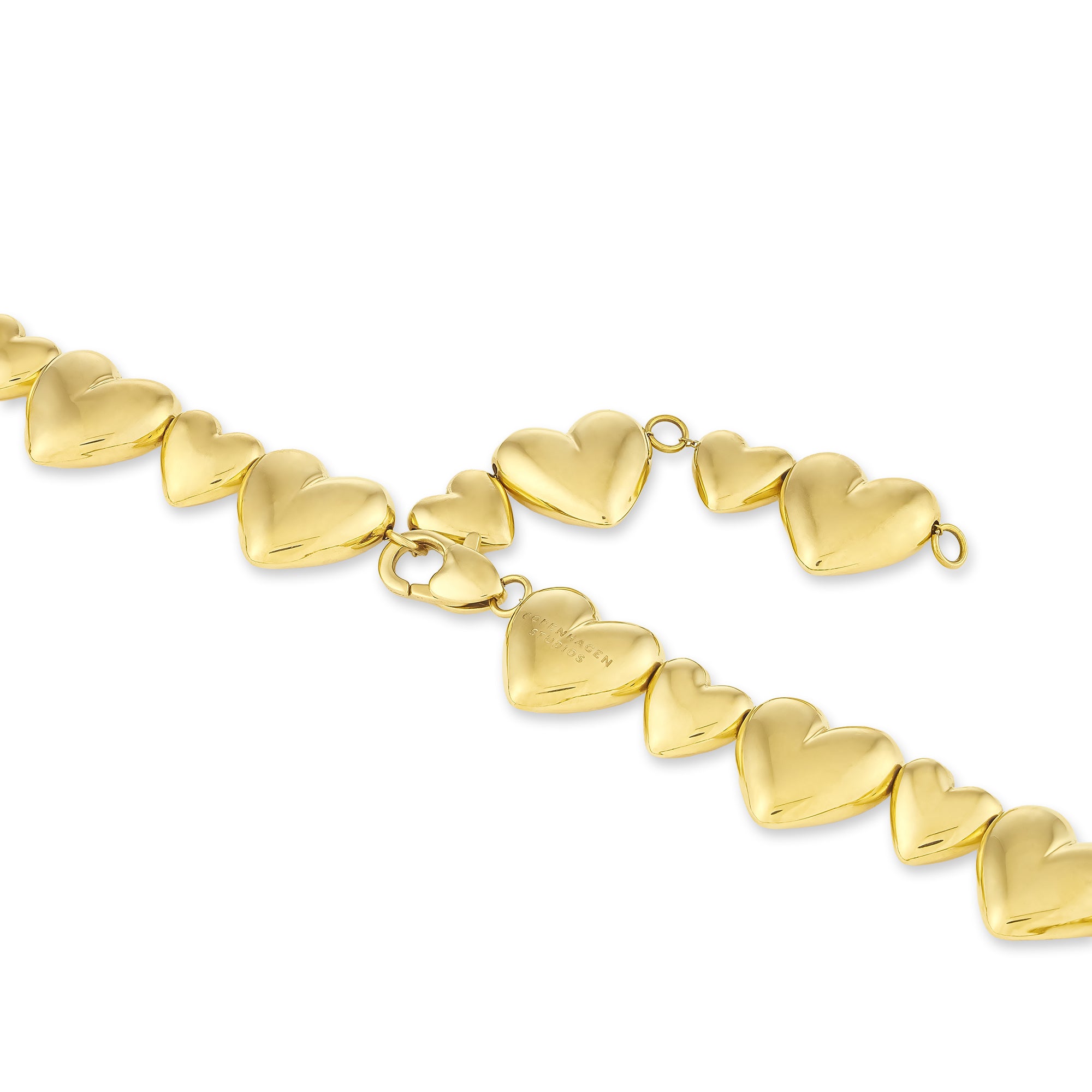 Goldfarbenes Armband mit verknüpften, geschwollenen Herzanhängern und einem Herzkarabiner-Verschluss, inspiriert von der COPENHAGEN STUDIOS Halskette - Puffy Hearts by Copenhagen Studios, auf weißem Hintergrund.