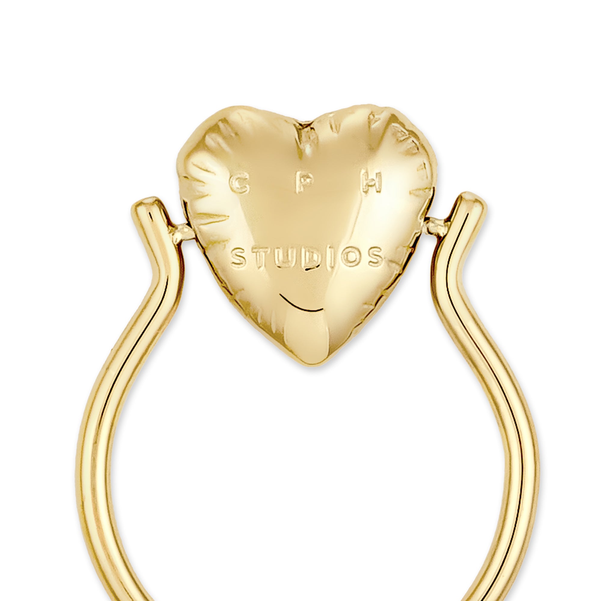 Der Ring COPENHAGEN STUDIOS - Balloon Hearts von Copenhagen Studios besteht aus einem herzförmigen Ring, in den die Marke eingraviert ist und der auf einem geschwungenen Band sitzt - ein elegantes Schmuckstück, das von der Balloon Hearts-Kollektion der Marke inspiriert ist.