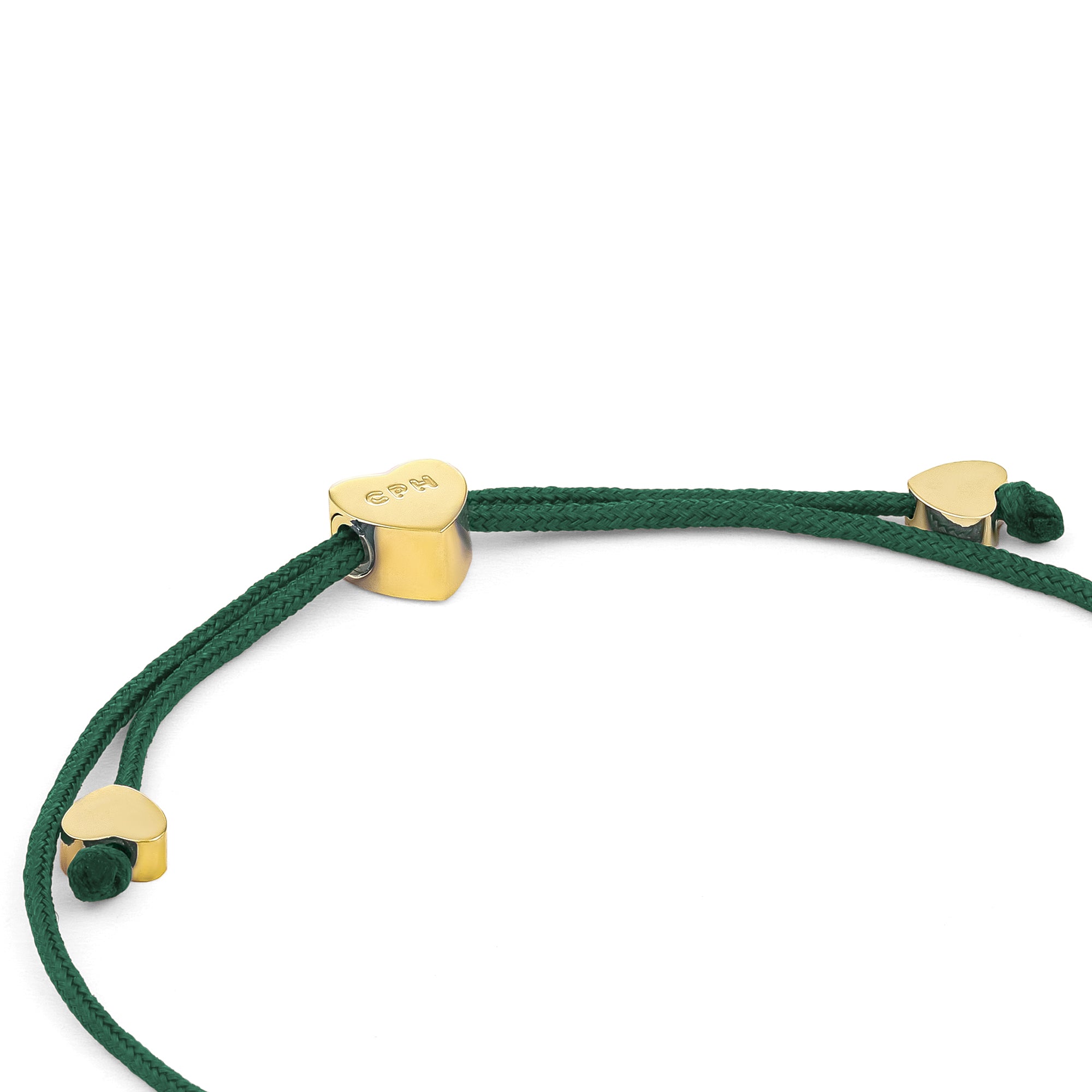 Copenhagen Studios Armband - Ballonherzen: Grünes Kordelarmband mit drei goldenen Herzanhängern, einer mit eingravierten Buchstaben, auf weißem Hintergrund.