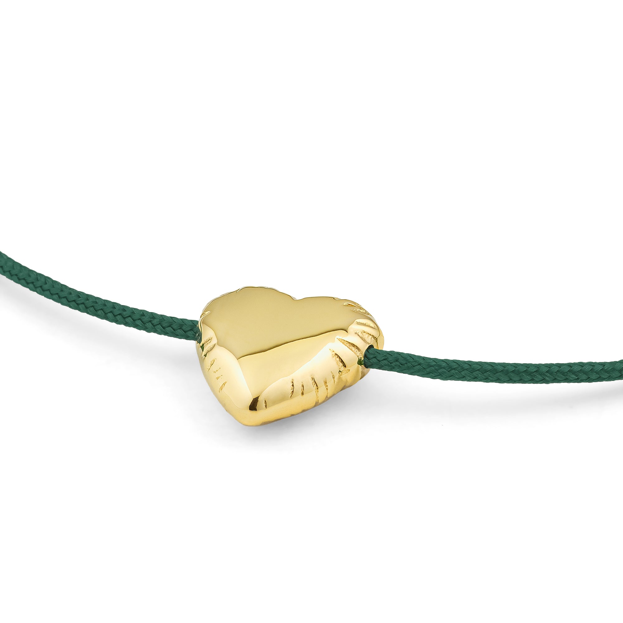 Das COPENHAGEN STUDIOS Armband - Balloon Hearts zeigt einen goldenen Herzanhänger auf einer grünen, geflochtenen Kordel, inspiriert von dem klassischen Balloon Hearts Slider Bracelet, und hebt sich schön von einem weißen Hintergrund ab.