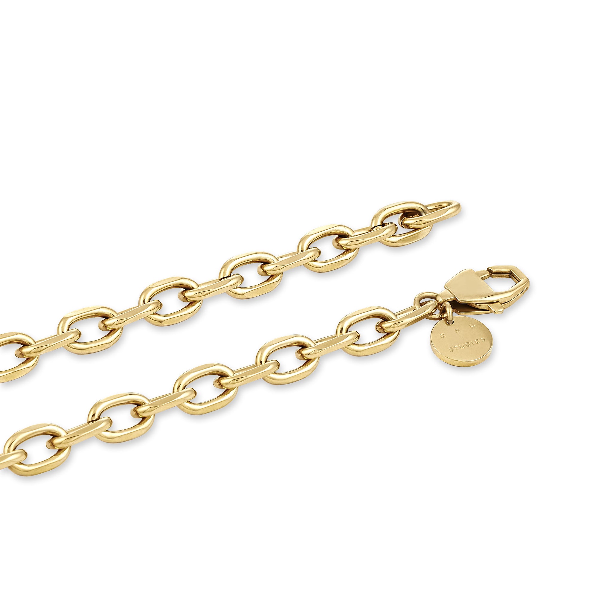 Nahaufnahme des Armbands COPENHAGEN STUDIOS - Basic Chains von Copenhagen Studios mit ovalen Gliedern in Gold und einem runden Anhänger in der Nähe des Verschlusses - ein elegantes Accessoire auf weißem Hintergrund.