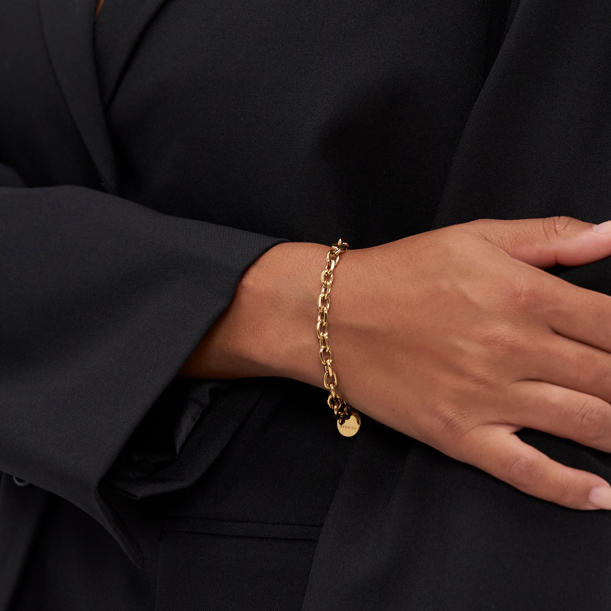 Eine Person in Schwarz trägt das Copenhagen Studios Armband - Basic Chains und setzt mit diesem schicken Accessoire ein markantes Zeichen am Handgelenk.
