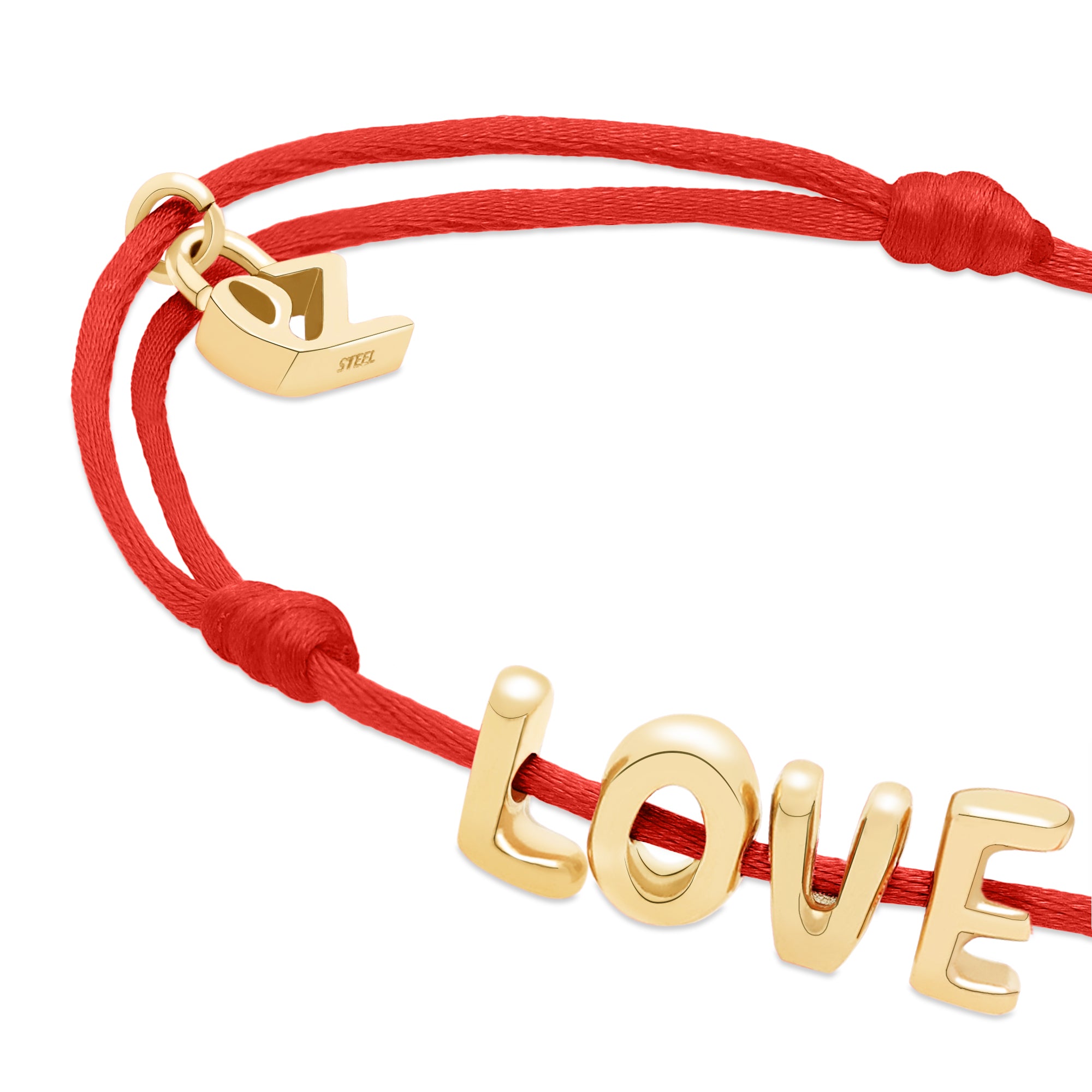 Das Echtzeit Armband - Love Letters von Echtzeit: Rotes Stoffband mit goldenen "LOVE" Buchstaben und Herz-Charm - ein liebevolles Geschenk für jeden Anlass.