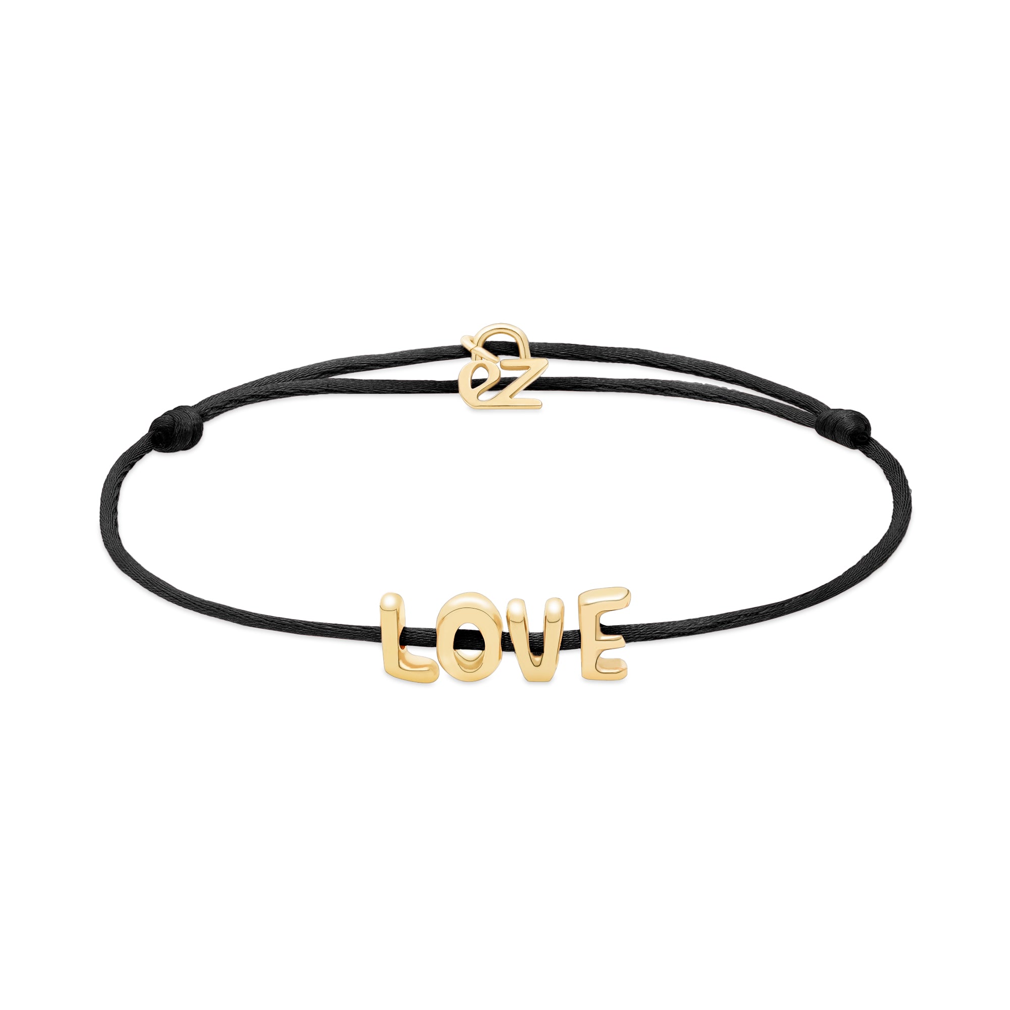 Das Echtzeit Armband - Love Letters von Echtzeit besteht aus einem schwarzen Stoffband mit goldenen LOVE Buchstaben und einer goldenen Schließe, die auf einem weißen Hintergrund abgebildet sind.