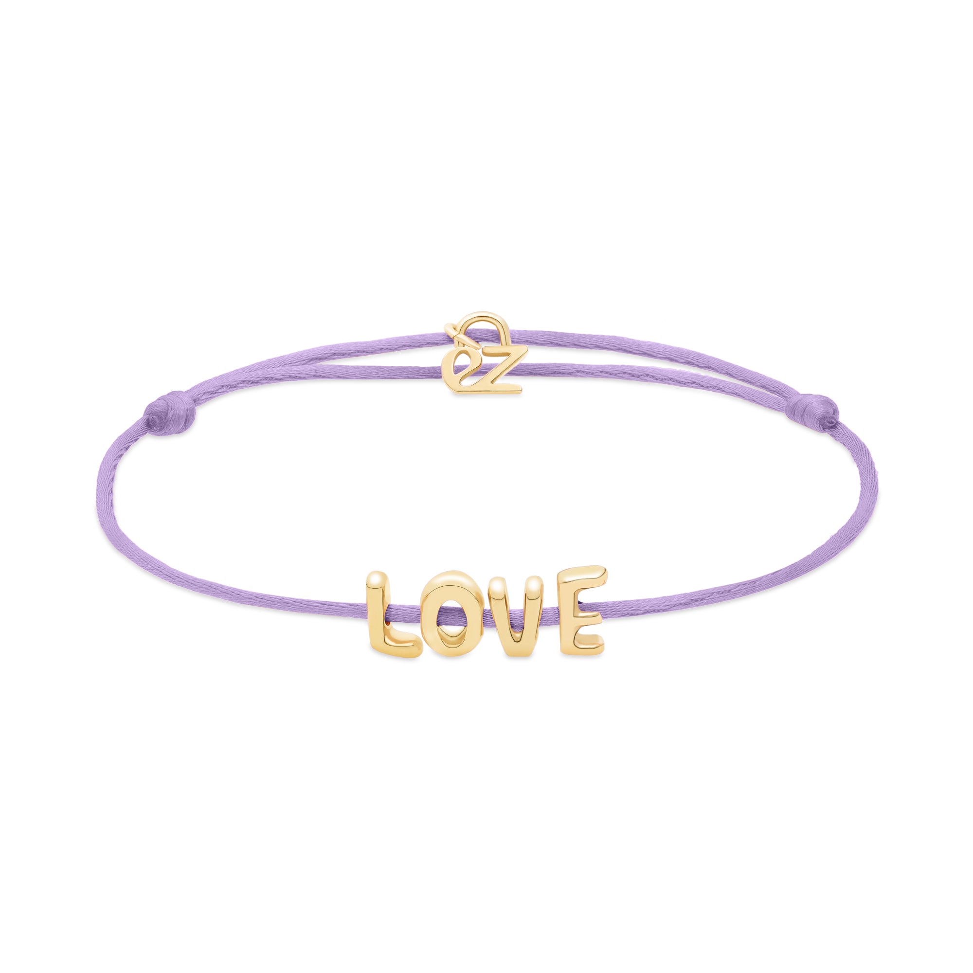 Das Echtzeit Armband - Love Letters von Echtzeit kombiniert ein lavendelfarbenes Stoffarmband mit goldenen LOVE-Buchstaben und Herzanhänger - ein bezauberndes Geschenk.