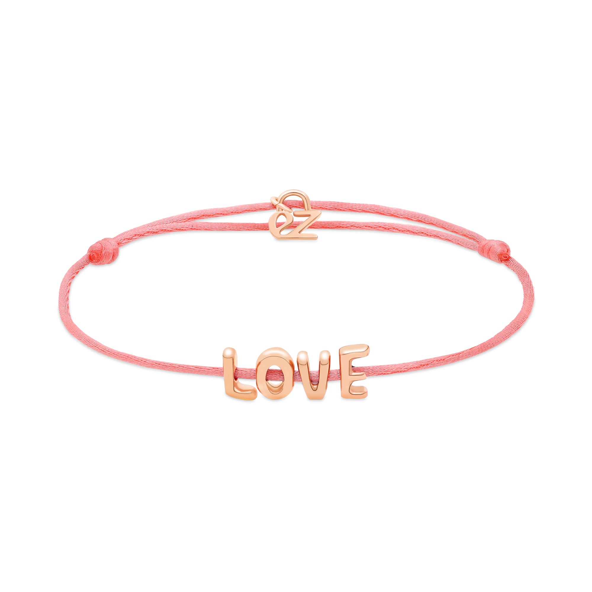 Das Echtzeit Armband - Love Letters von Echtzeit mit LOVE-Buchstabenanhänger und goldfarbenem Verschluss ist ein stilvolles Geschenk auf weißem Hintergrund.