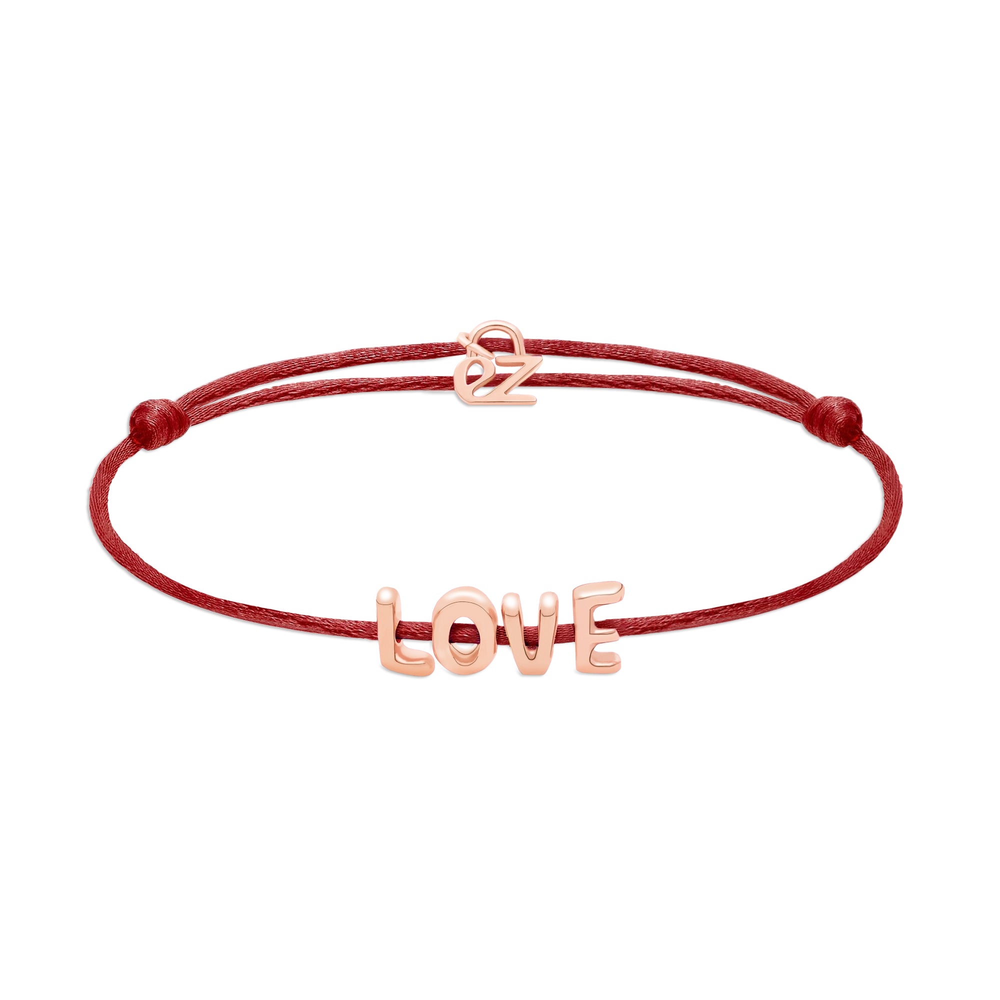 Das Echtzeit Armband - Love Letters von Echtzeit hat eine rote Kordel mit goldenen LOVE-Buchstaben und einem "oz"-Anhänger - perfekt als Geschenk für einen besonderen Menschen.