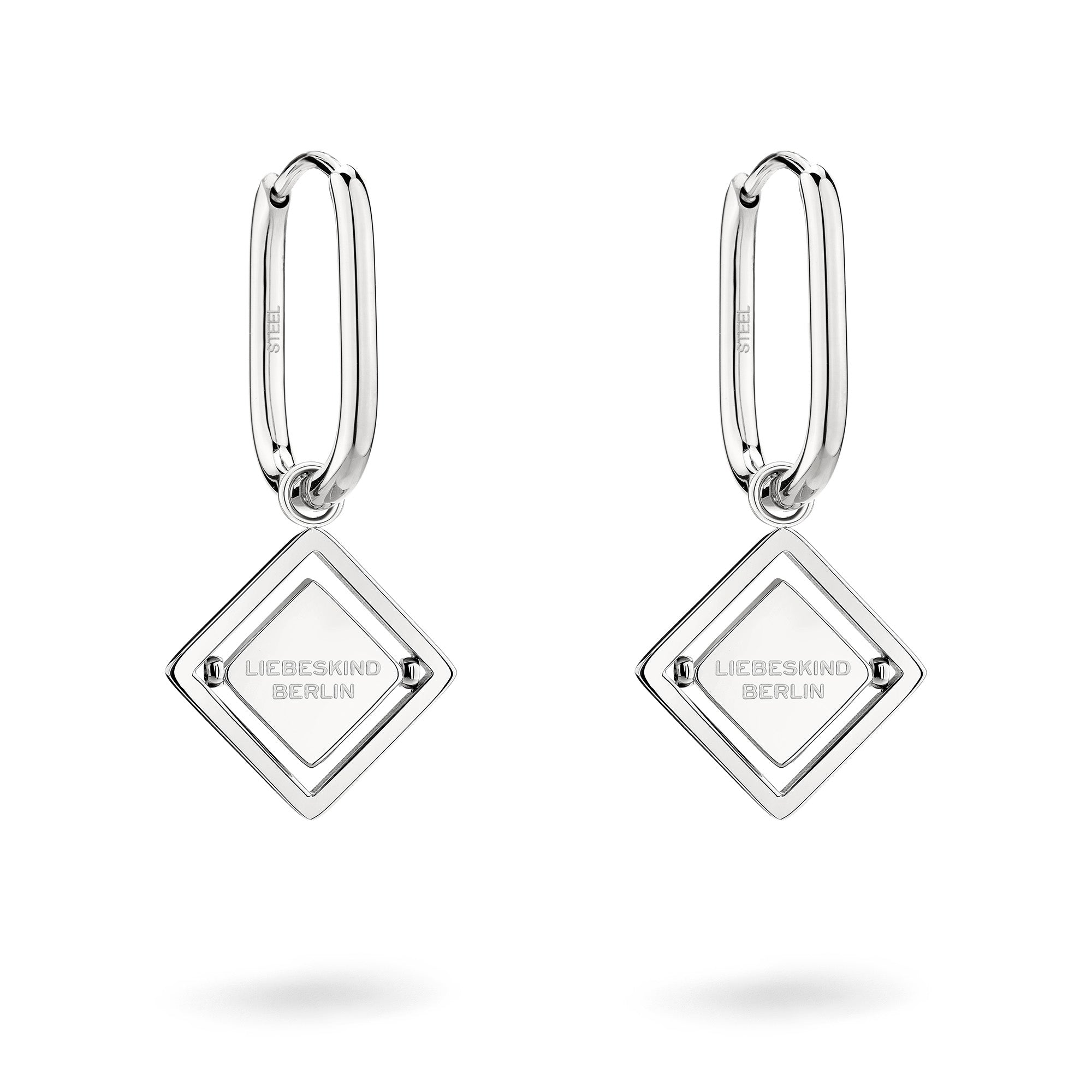 LIEBESKIND BERLIN Ohrhänger - Swinging Icon von Liebeskind Berlin sind silberne Creolen mit rautenförmigen Logomania-Anhängern, in die LIEBESKIND BERLIN eingraviert ist. Sie glänzen elegant vor weißem Hintergrund.