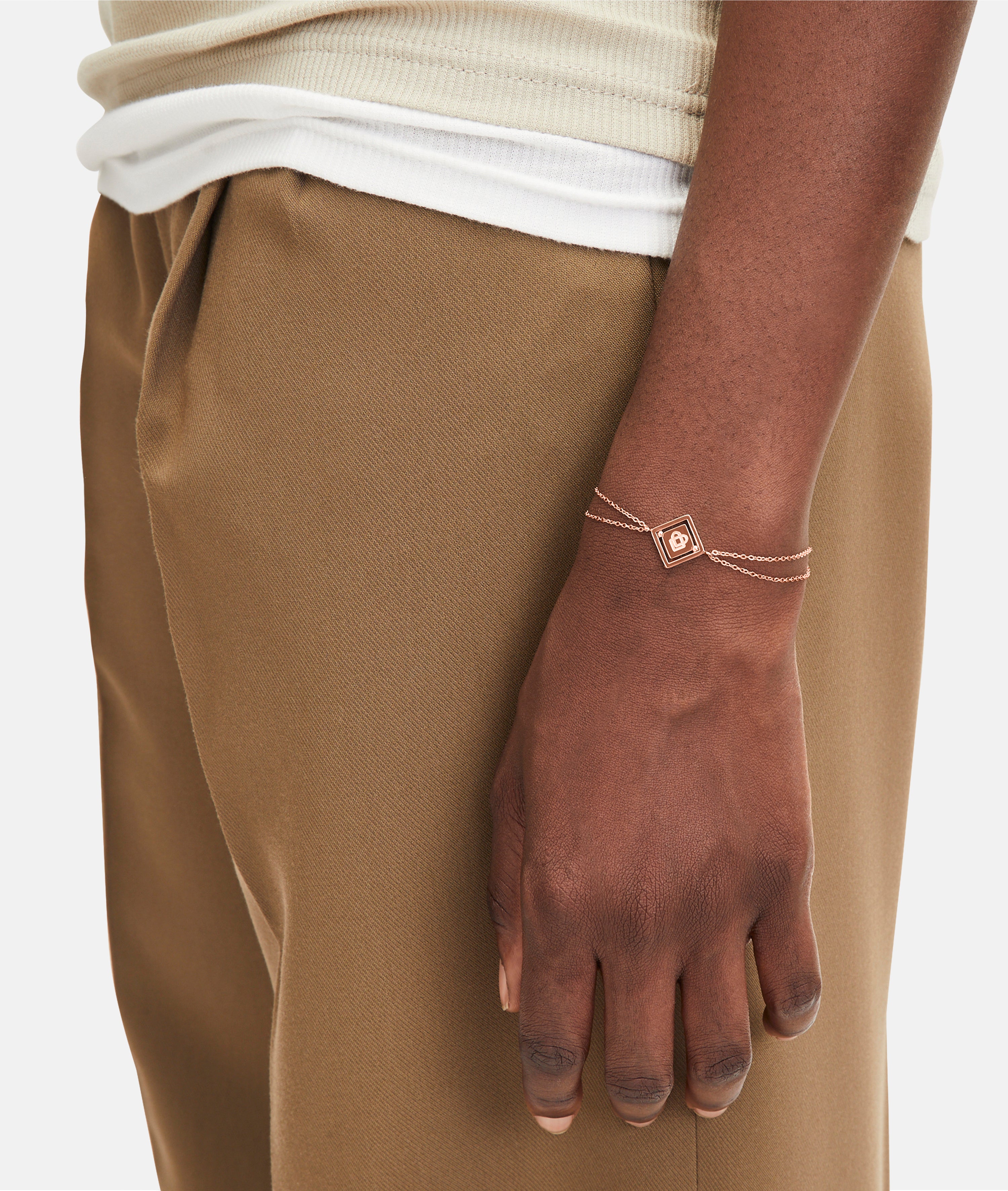 Liebeskind Berlin Armband bestehend aus einer doppelten, roségoldenen Ankerkette und einem drehbaren Anhänger mit graviertem Logo auf der einen und graviertem Logoschriftzug auf der anderen Seite; Tragebild