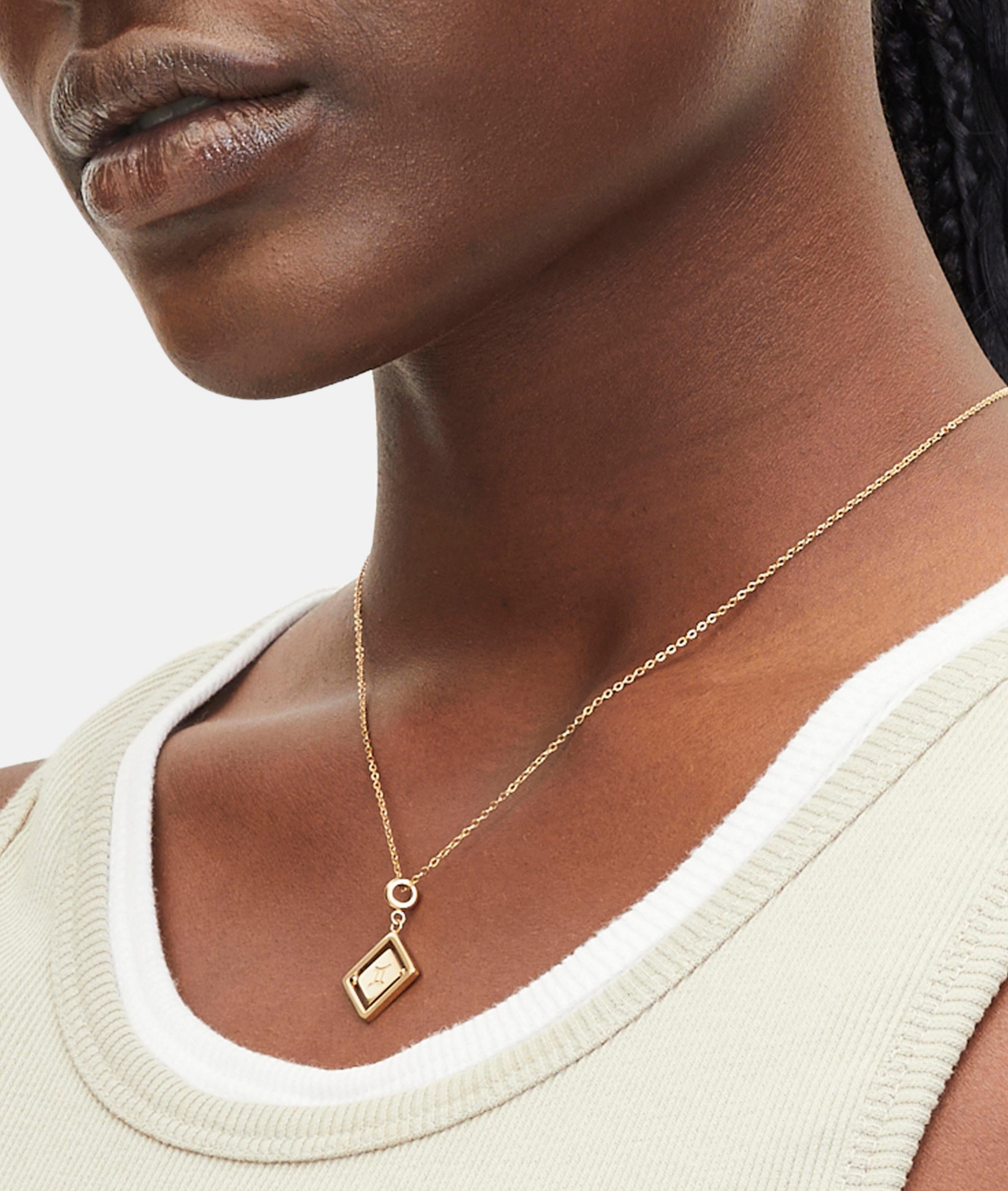 Goldener Liebeskind Berlin Charm mit drehbarem Plättchen, graviertem Zwilling-Zodiac-Symbol auf der einen und Logoschriftzug auf der anderen Seite; Tragebild