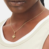 Goldener Liebeskind Berlin Charm mit drehbarem Plättchen, graviertem Löwe-Zodiac-Symbol auf der einen und Logoschriftzug auf der anderen Seite; Tragebild
