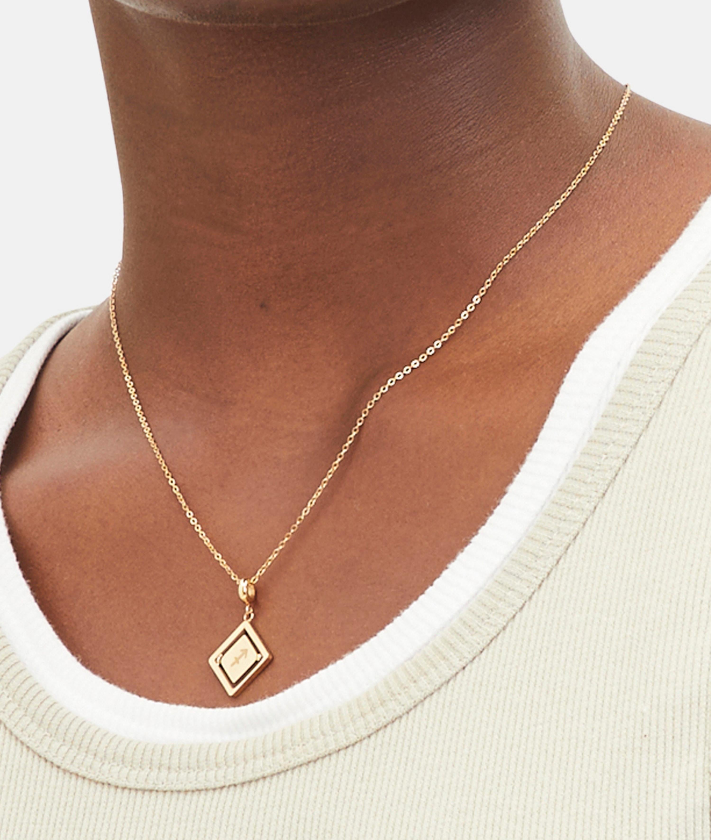Goldener Liebeskind Berlin Charm mit drehbarem Plättchen, graviertem Schütze-Zodiac-Symbol auf der einen und Logoschriftzug auf der anderen Seite; Tragebild