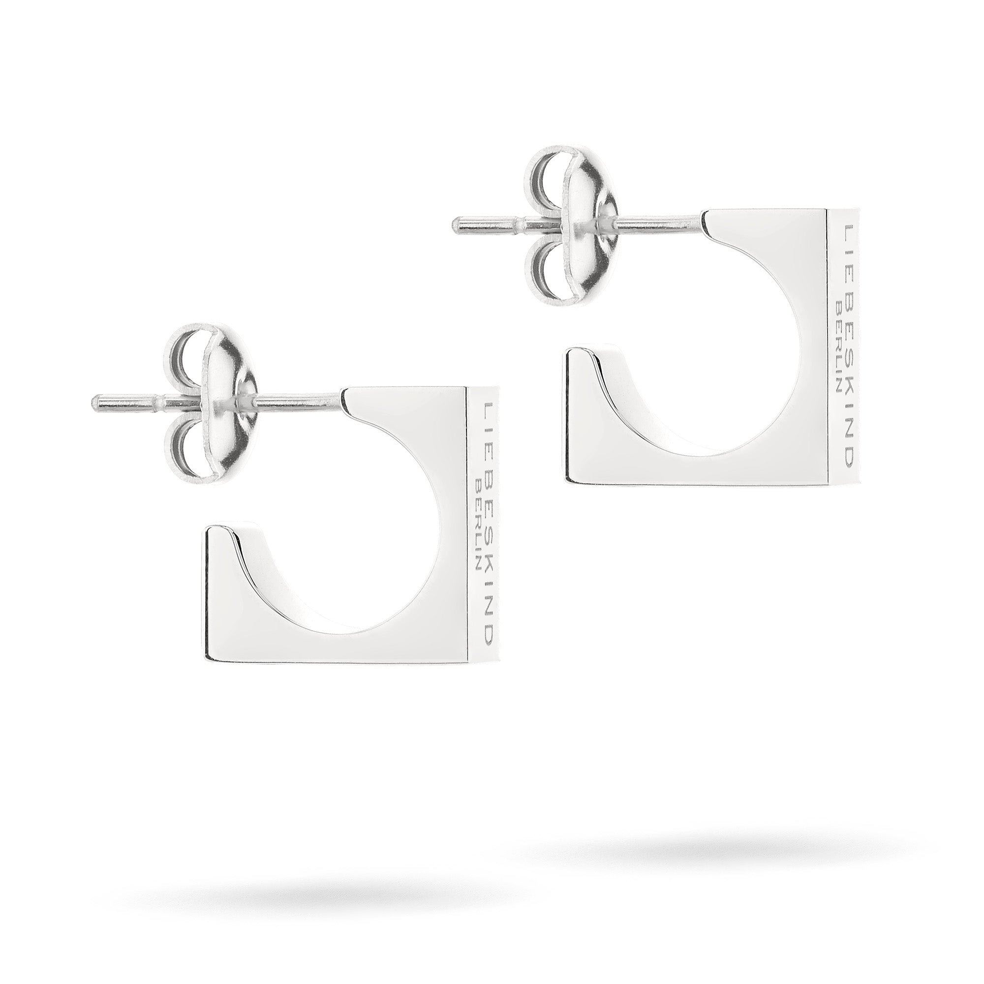 LIEBESKIND BERLIN Creole - Urban Chic Ohrringe von Liebeskind Berlin sind quadratische silberne Ohrstecker mit eingravierten Details, die ein schickes Accessoire für Frauen darstellen. Abgebildet vor einem weißen Hintergrund.