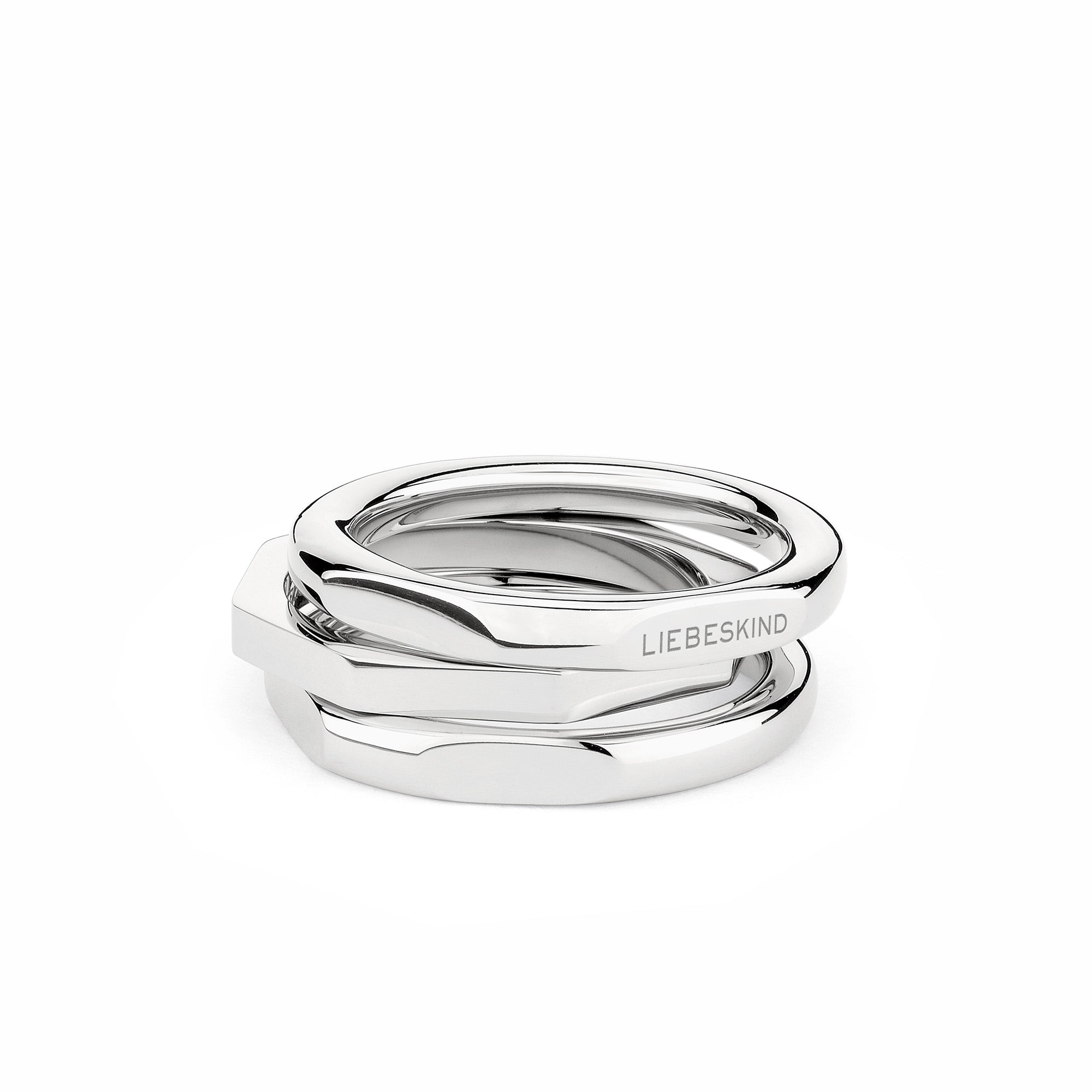 Drei gestapelte, ineinander verschlungene Silberringe der Serie LIEBESKIND BERLIN Ring - Urban Chic in Größe 56. Auf einem Ring ist "LIEBESKIND" von Liebeskind Berlin eingraviert, auf weißem Grund.