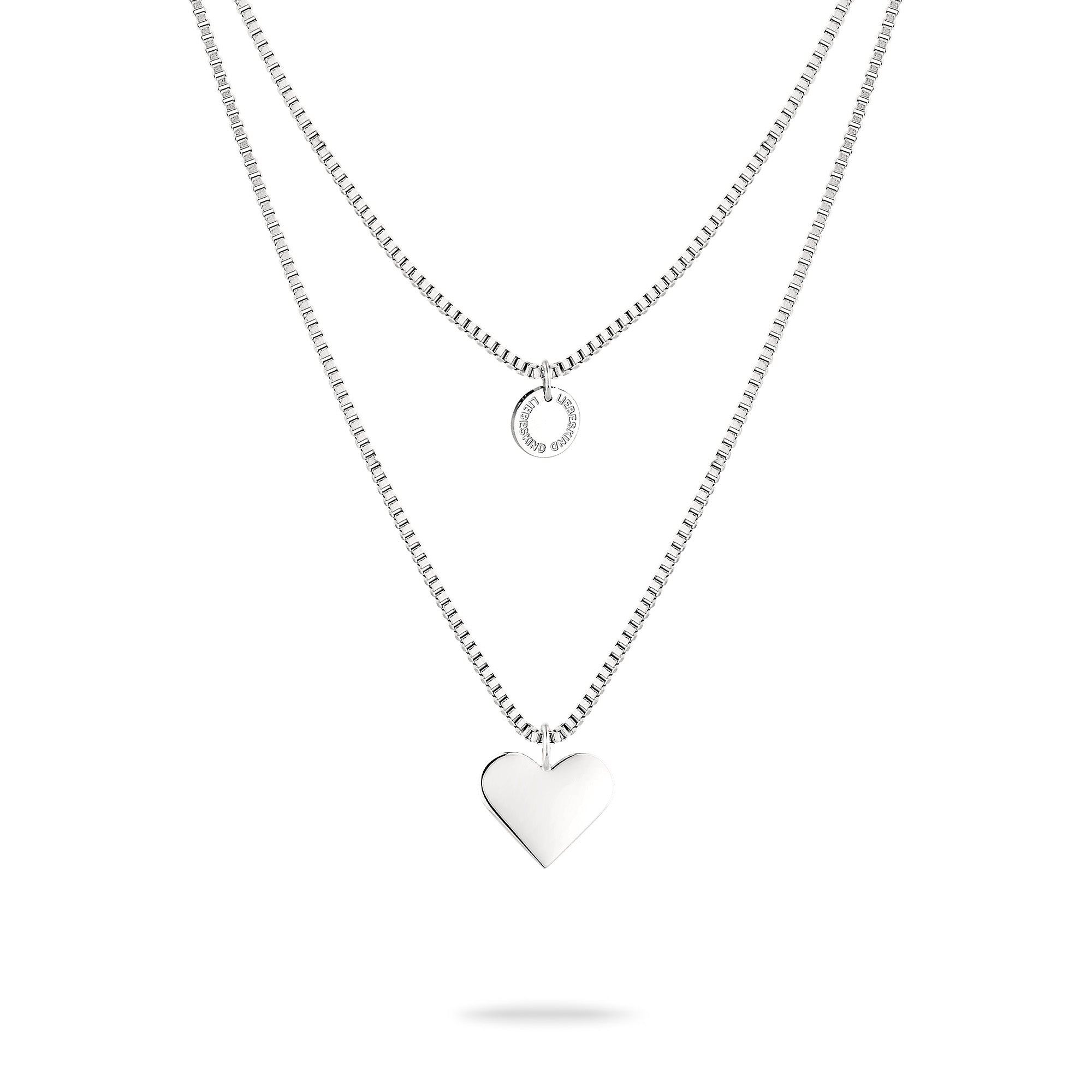 Die LIEBESKIND BERLIN Halskette - Layered Love von Liebeskind Berlin besteht aus zwei Edelstahlketten: eine mit kleinem Kreisanhänger, die andere mit Herzanhänger, präsentiert auf weißem Hintergrund.
