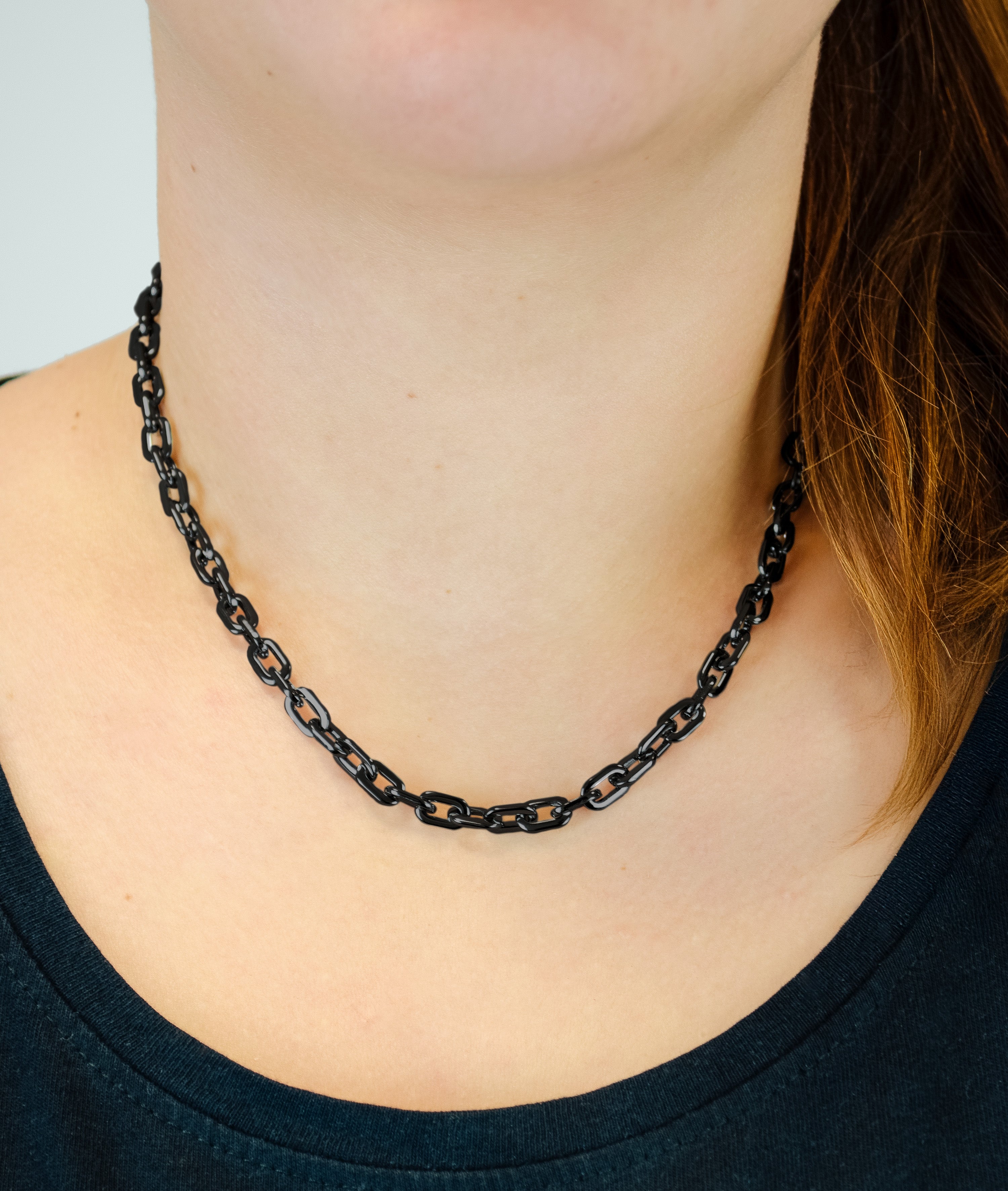Eine Person trägt die LIEBESKIND BERLIN Halskette - The Double Tag von Liebeskind Berlin mit einem dunklen Hemd, das vom Hals bis zu den Schultern reicht - eine subtile Anspielung auf den modernen Damen Schmuck Stil.