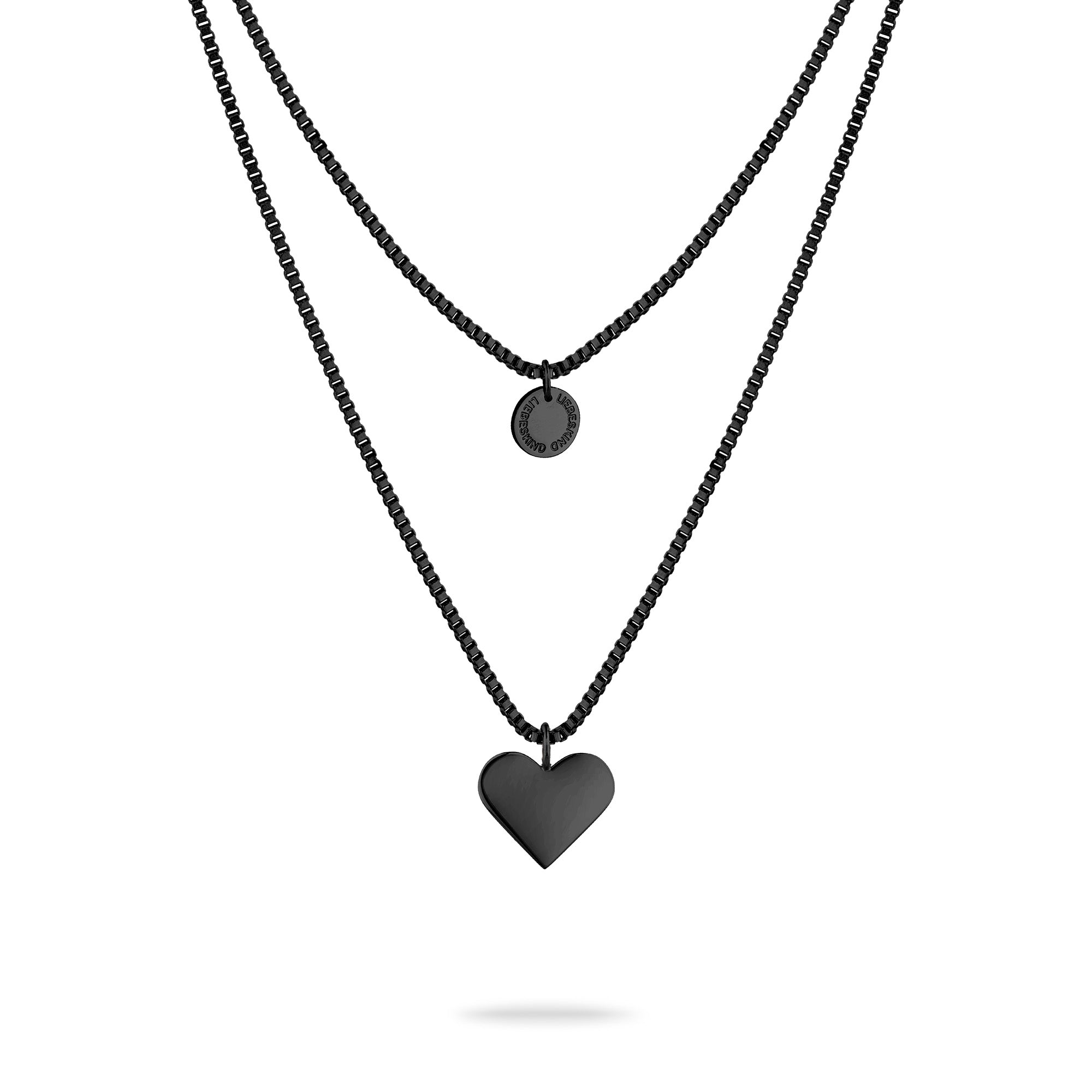 LIEBESKIND BERLIN Halskette - Layered Love: Zweigliedrige Edelstahlkette von Liebeskind Berlin mit schwarzem Kreis- und Herzanhänger auf weißem Hintergrund.