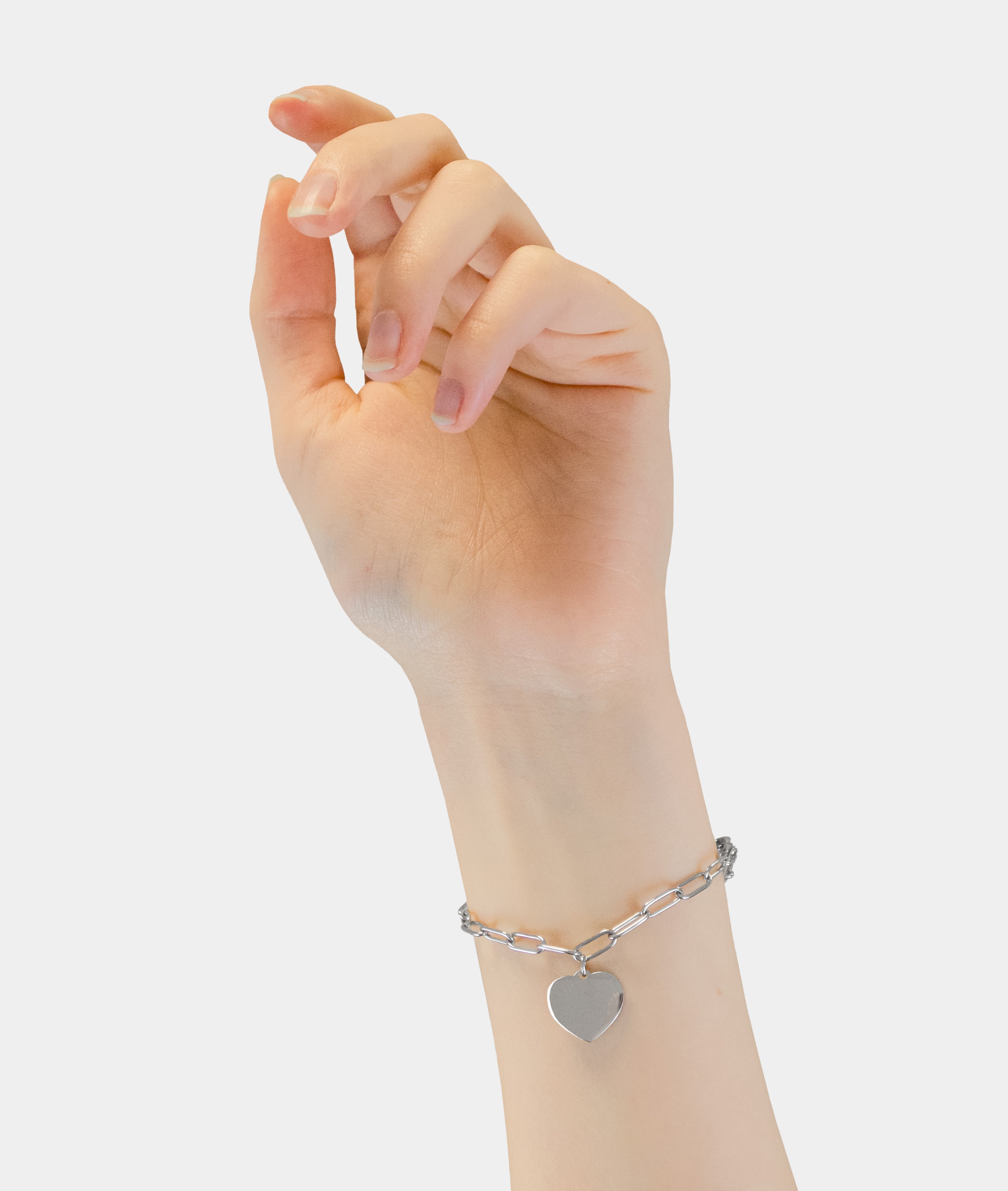 Eine Hand trägt das Liebeskind Berlin Armband - My Heart mit einem herzförmigen Anhänger, abgebildet auf weißem Hintergrund.