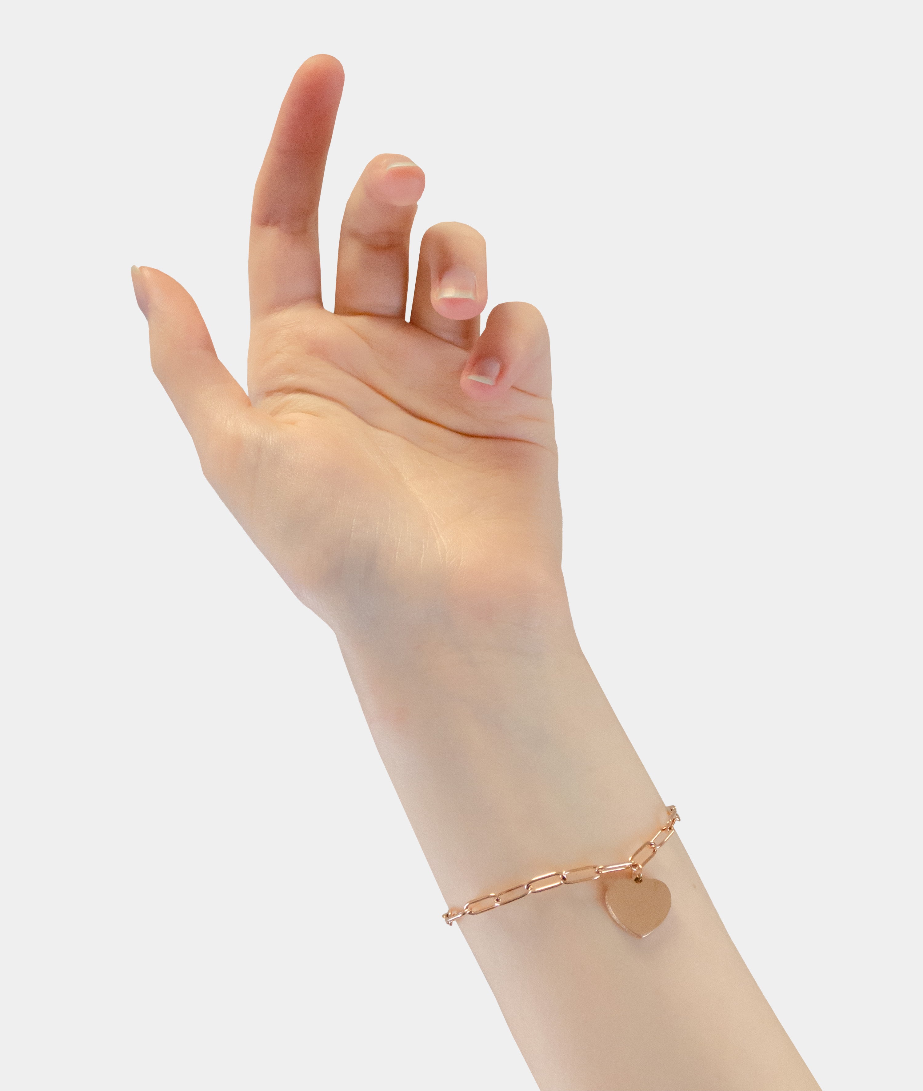 Eine Hand trägt das LIEBESKIND BERLIN Armband - My Heart von Liebeskind Berlin, dessen goldene Kette und Herzanhänger sanft das Licht einfangen - ein Stück, das moderne Eleganz verkörpert.