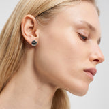 Eine Frau mit blondem Haar trägt den Liebeskind Berlin Ohrring - Organic Shapes in einer Nahaufnahme im Seitenprofil vor einem schlichten Hintergrund - ein elegantes Accessoire von Liebeskind Berlin für jeden Anlass.