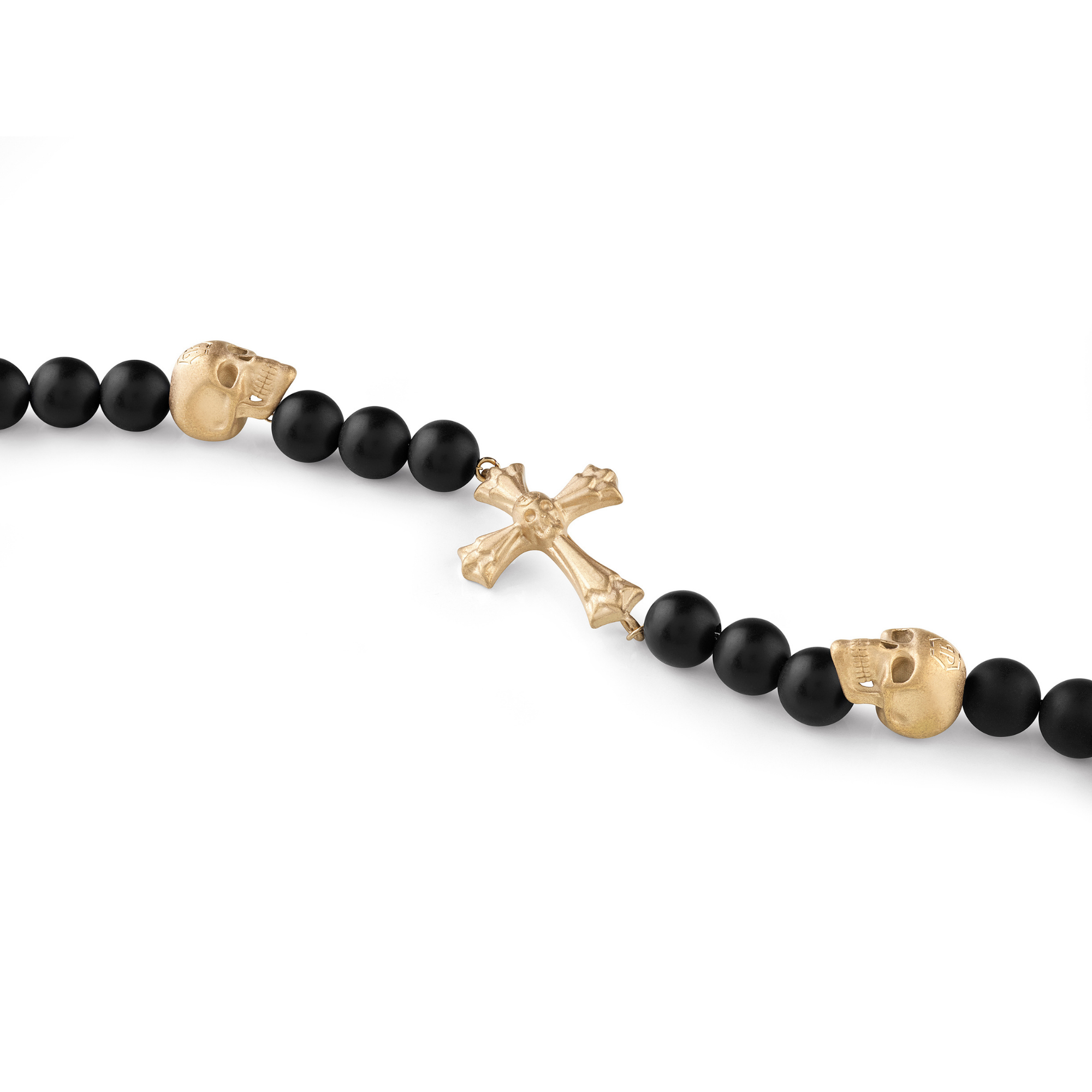 Das Philipp Plein Armband - PP WHISPER von Philipp Plein ist mit schwarzen Perlen, goldenen Totenköpfen und einem goldenen Kreuz verziert und hebt Schwarz und Gold vor einem weißen Hintergrund hervor.
