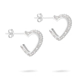 Die Tamaris Creole - Sparkling Hearts von Tamaris sind herzförmige Ohrstecker aus 925er Silber, die mit funkelnden Zirkoniasteinen auf weißem Hintergrund verziert sind.