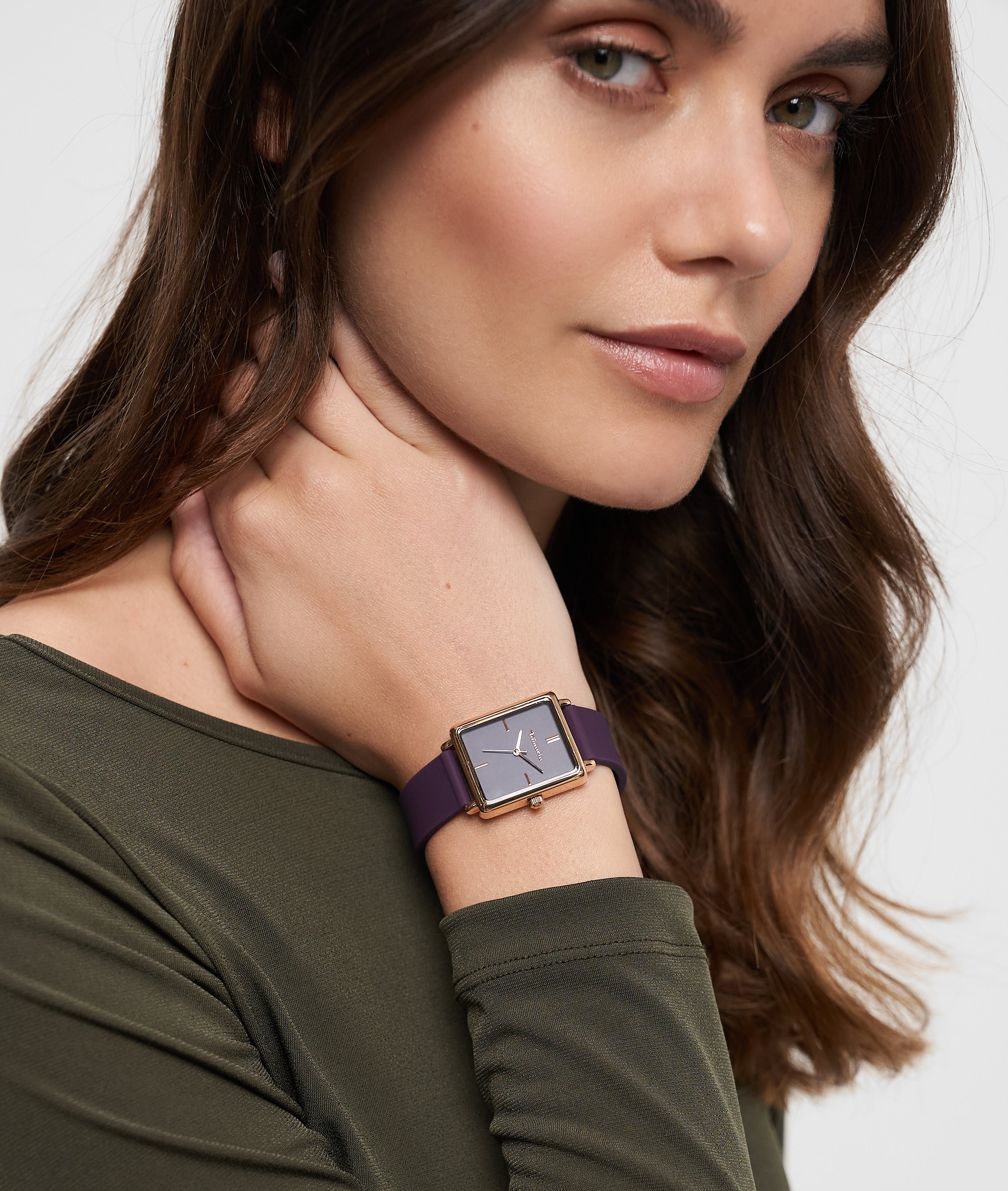 Frau mit langen braunen Haaren trägt ein olivgrünes Oberteil und eine Tamaris Armbanduhr - The Silicon Square von Tamaris und schaut in die Kamera.