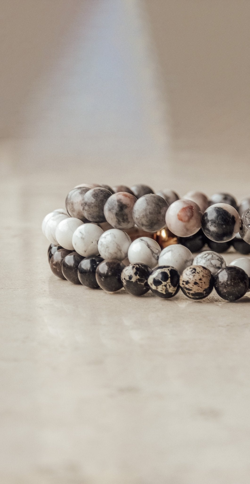 Nahaufnahme zweier Beads-Armbänder von LIEBESKIND BERLIN aus natürlichen Steinperlen in Beige- und Brauntönen – stylisch, modern und unisex tragbar.