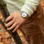 Cool Time Kids Armbanduhr mit einem silbernen Zifferblatt mit glitzernden Schmetterlingen, silbernem Gehäuse und silbernem Meshband; Tragebild