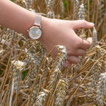 Cool Time Kids Armbanduhr mit einem silbernen Zifferblatt mit glitzernden Schmetterlingen, roségoldenem Gehäuse und roségoldenem Meshband; Tragebild