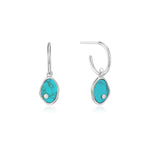 Die Ania Haie Creole - Turquoise Hidden Gem Ohrringe von Ania Haie zeichnen sich durch türkisfarbene Steine und klare Edelsteine in Sterlingsilberringen aus, die lebendige Farben und Eleganz auf einem weißen Hintergrund bieten.